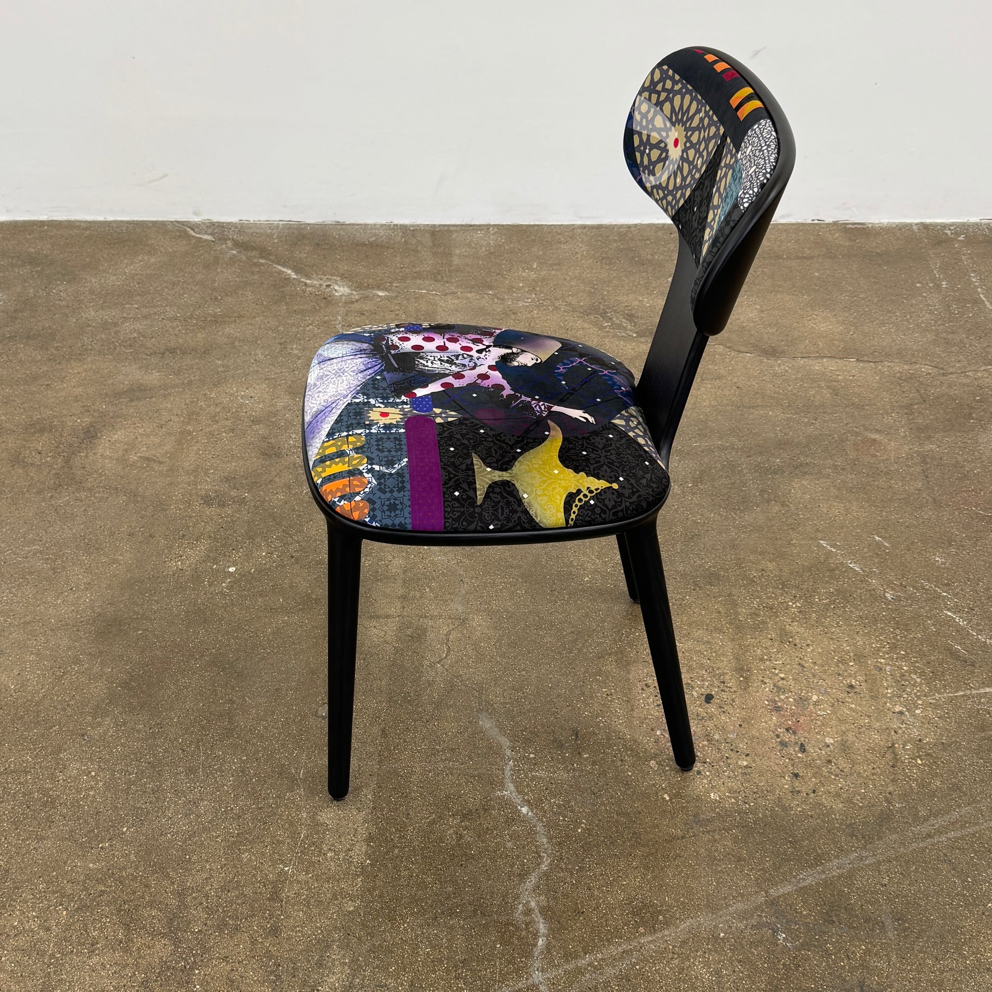 A set of six black Roche Bobois Globe Trotter Operette dining chairs, featuring patterned cushions and backs, arranged in two rows against a plain white background.