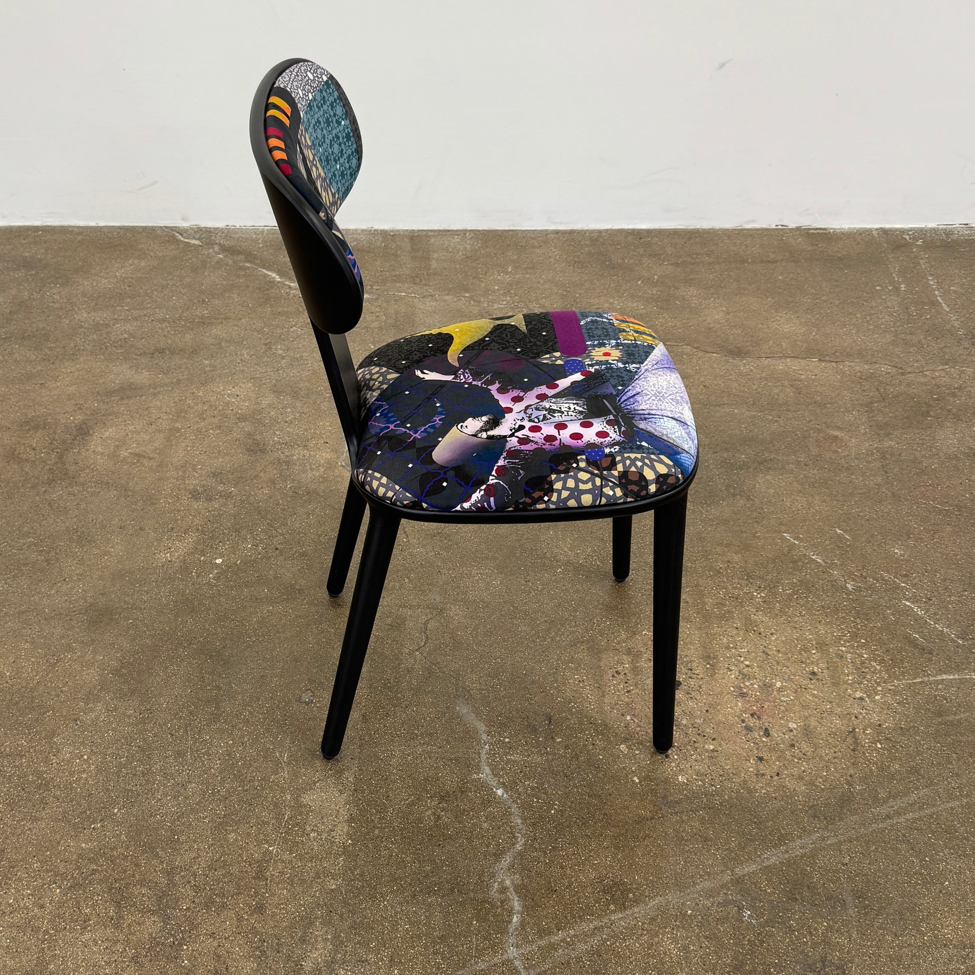 A set of six black Roche Bobois Globe Trotter Operette dining chairs, featuring patterned cushions and backs, arranged in two rows against a plain white background.