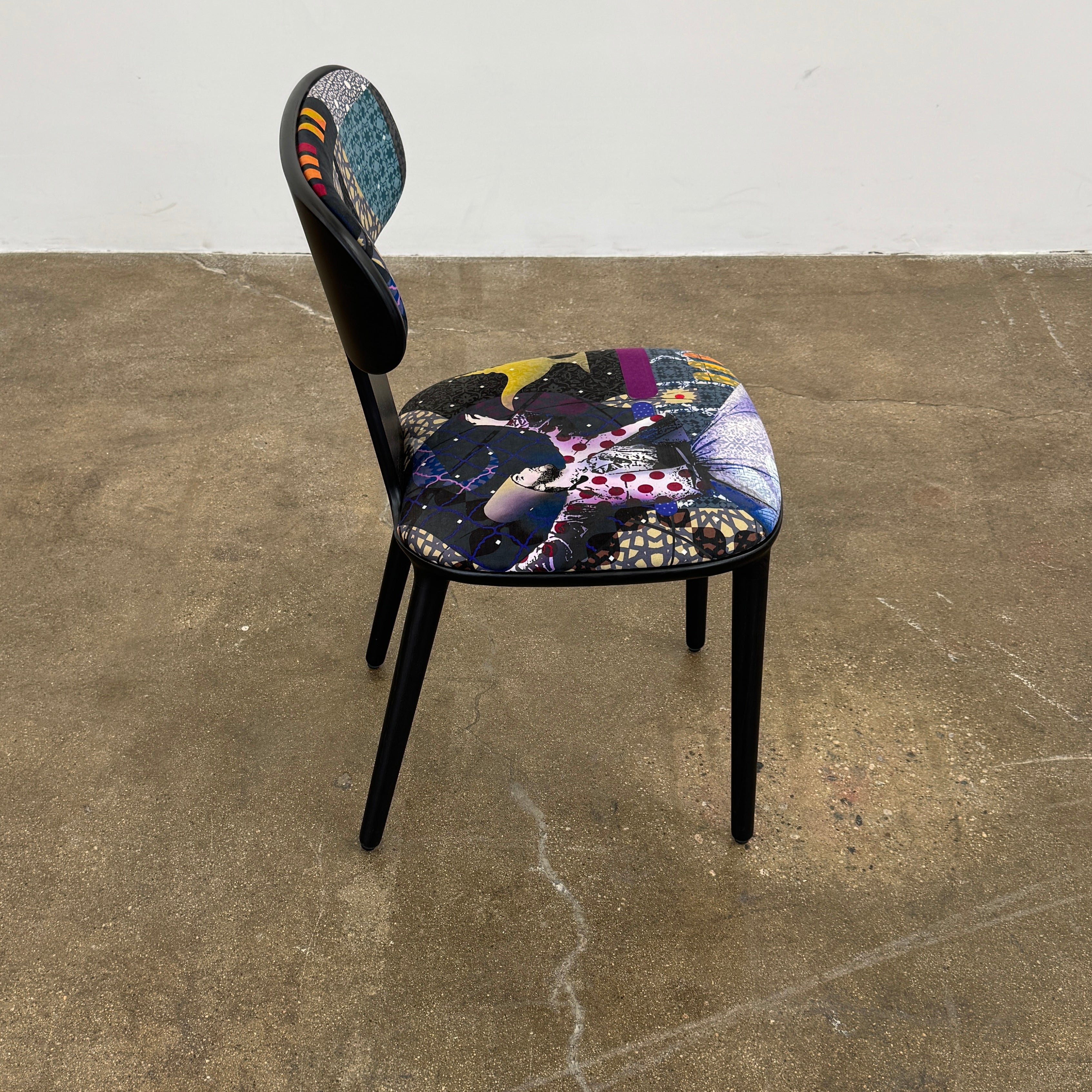 A set of six black Roche Bobois Globe Trotter Operette dining chairs, featuring patterned cushions and backs, arranged in two rows against a plain white background.