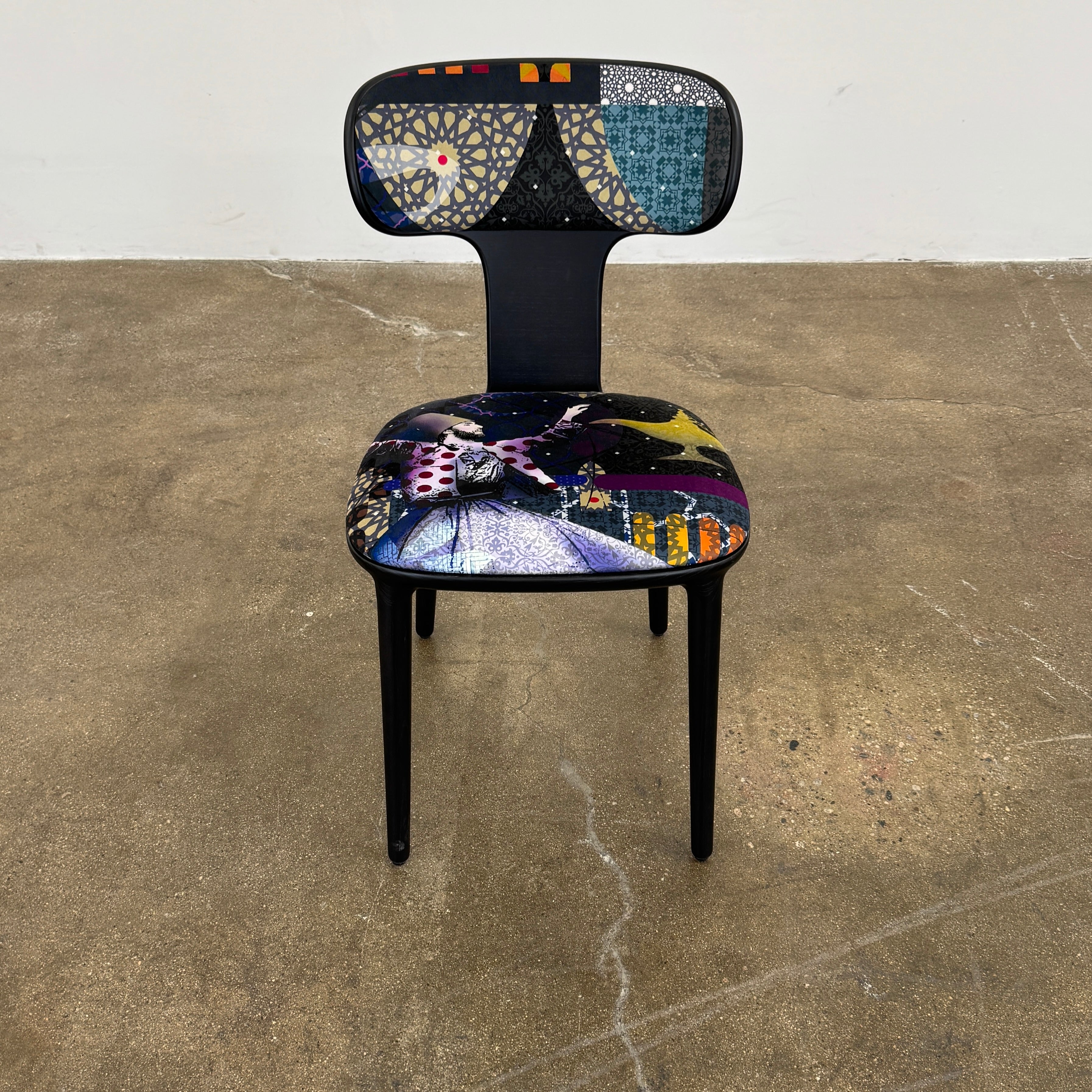 A set of six black Roche Bobois Globe Trotter Operette dining chairs, featuring patterned cushions and backs, arranged in two rows against a plain white background.