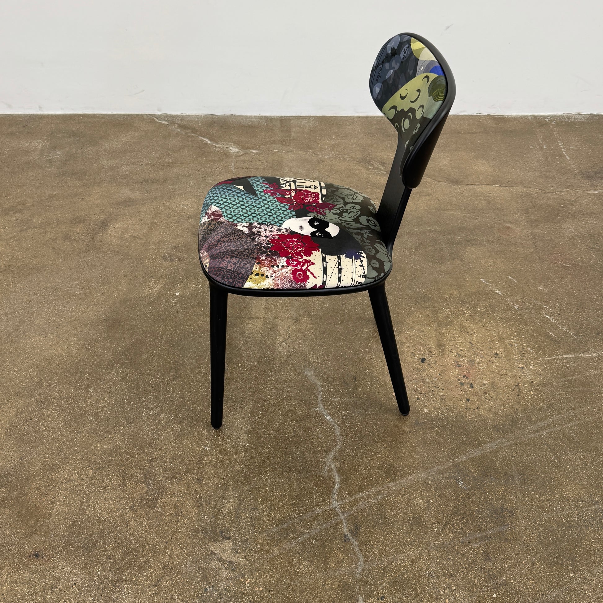 A set of six black Roche Bobois Globe Trotter Operette dining chairs, featuring patterned cushions and backs, arranged in two rows against a plain white background.