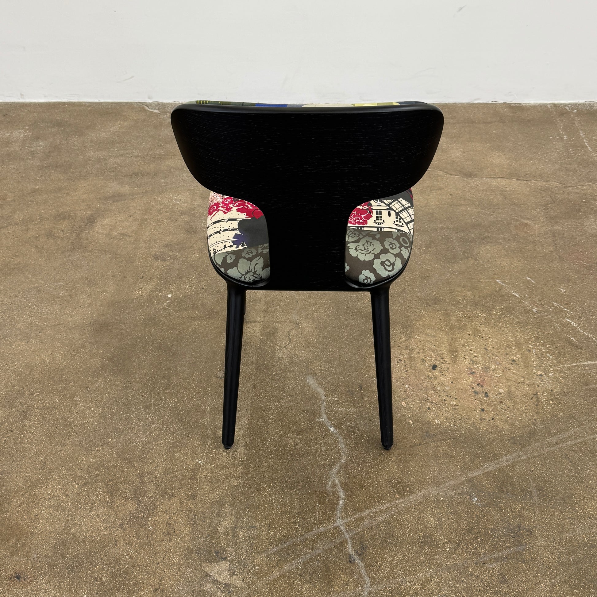 A set of six black Roche Bobois Globe Trotter Operette dining chairs, featuring patterned cushions and backs, arranged in two rows against a plain white background.