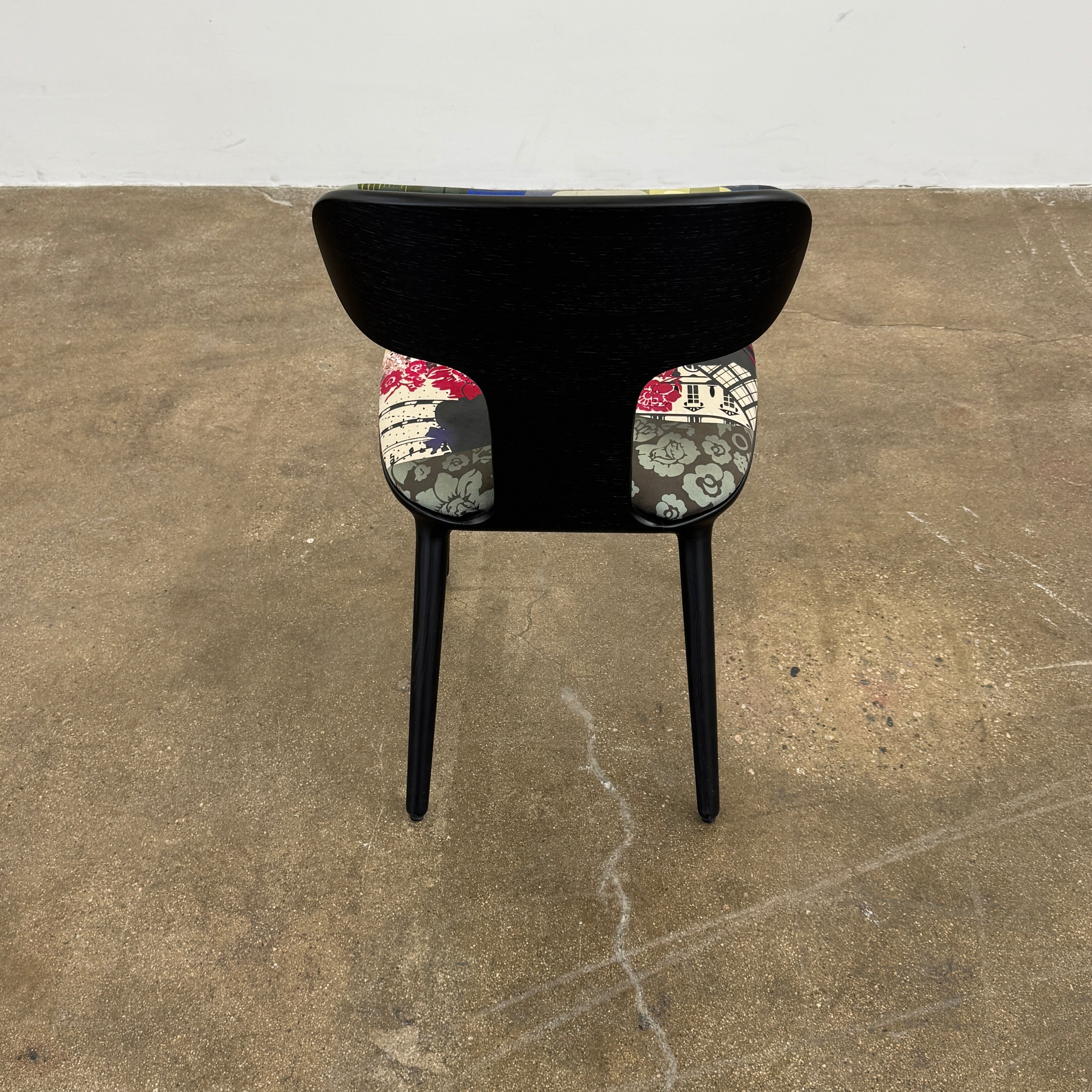 A set of six black Roche Bobois Globe Trotter Operette dining chairs, featuring patterned cushions and backs, arranged in two rows against a plain white background.