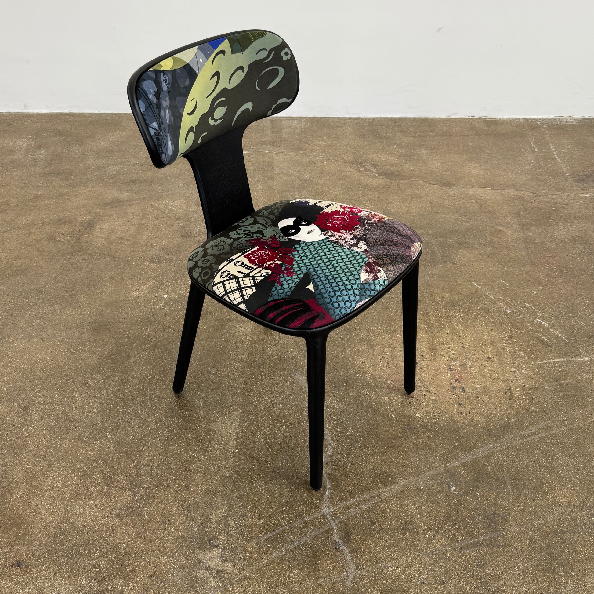 A set of six black Roche Bobois Globe Trotter Operette dining chairs, featuring patterned cushions and backs, arranged in two rows against a plain white background.