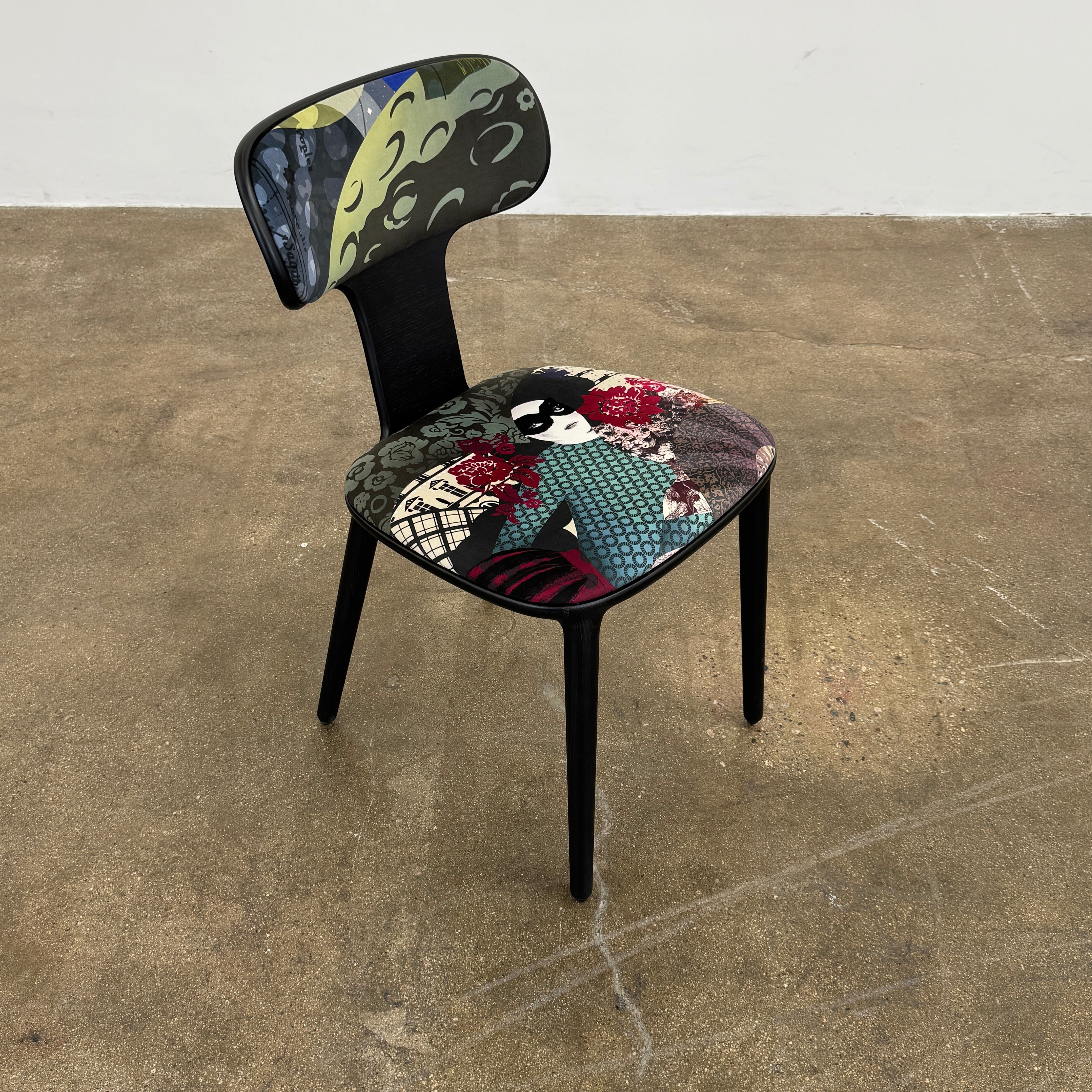 A set of six black Roche Bobois Globe Trotter Operette dining chairs, featuring patterned cushions and backs, arranged in two rows against a plain white background.