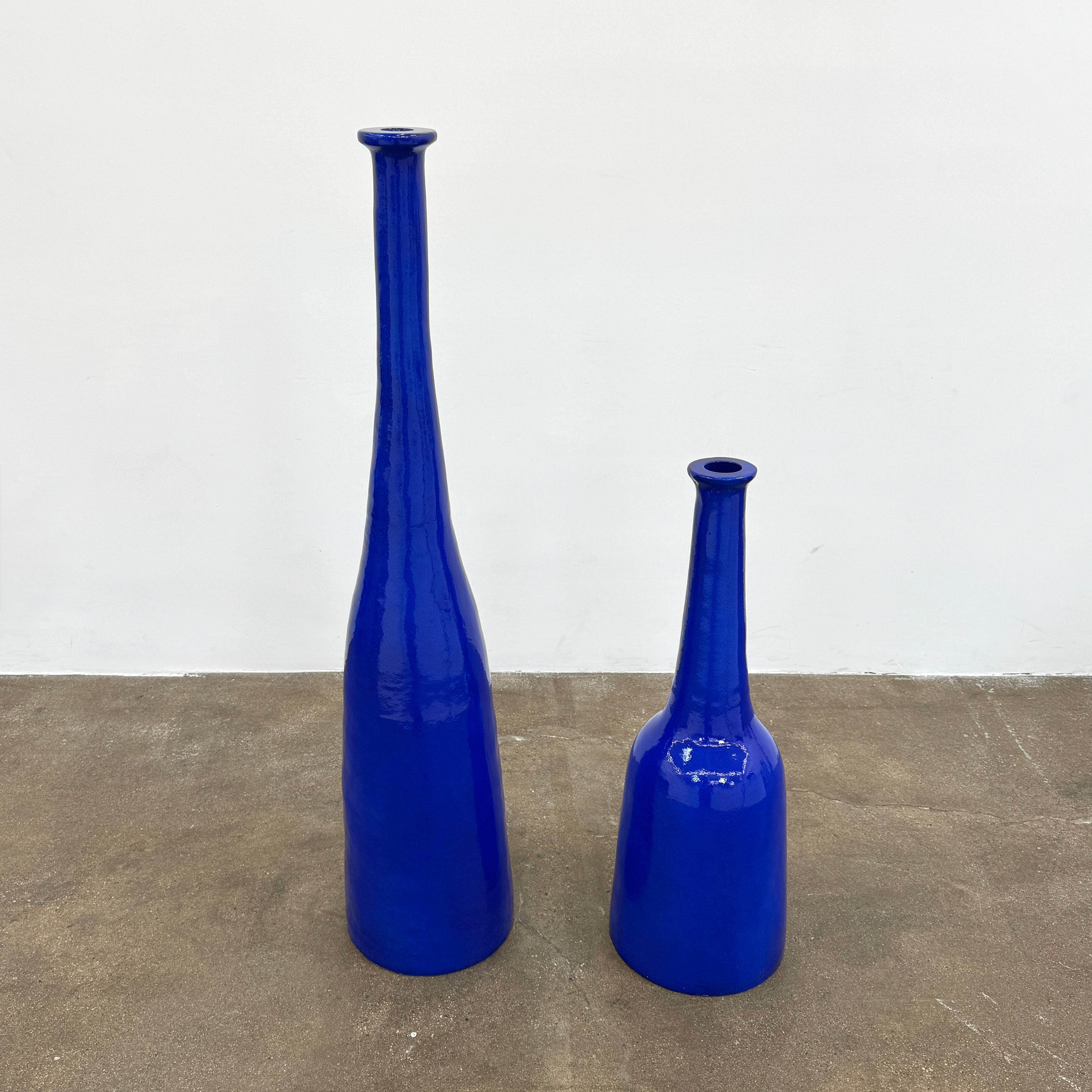 The Gervasoni In/Out Bottles, Set of 2 by Gervasoni features two glossy cobalt blue ceramic bottles of varying heights displayed side by side against a plain white background.