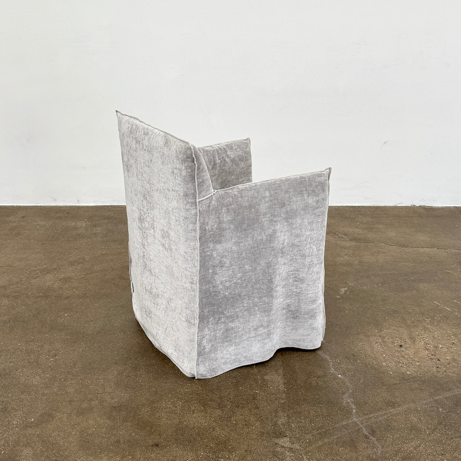 Four Gervasoni Ghost 25 Dining Armchairs by Gervasoni, featuring straight backs and skirted slipcovers in silver velvet, are arranged side by side against a white background for an elegant look.