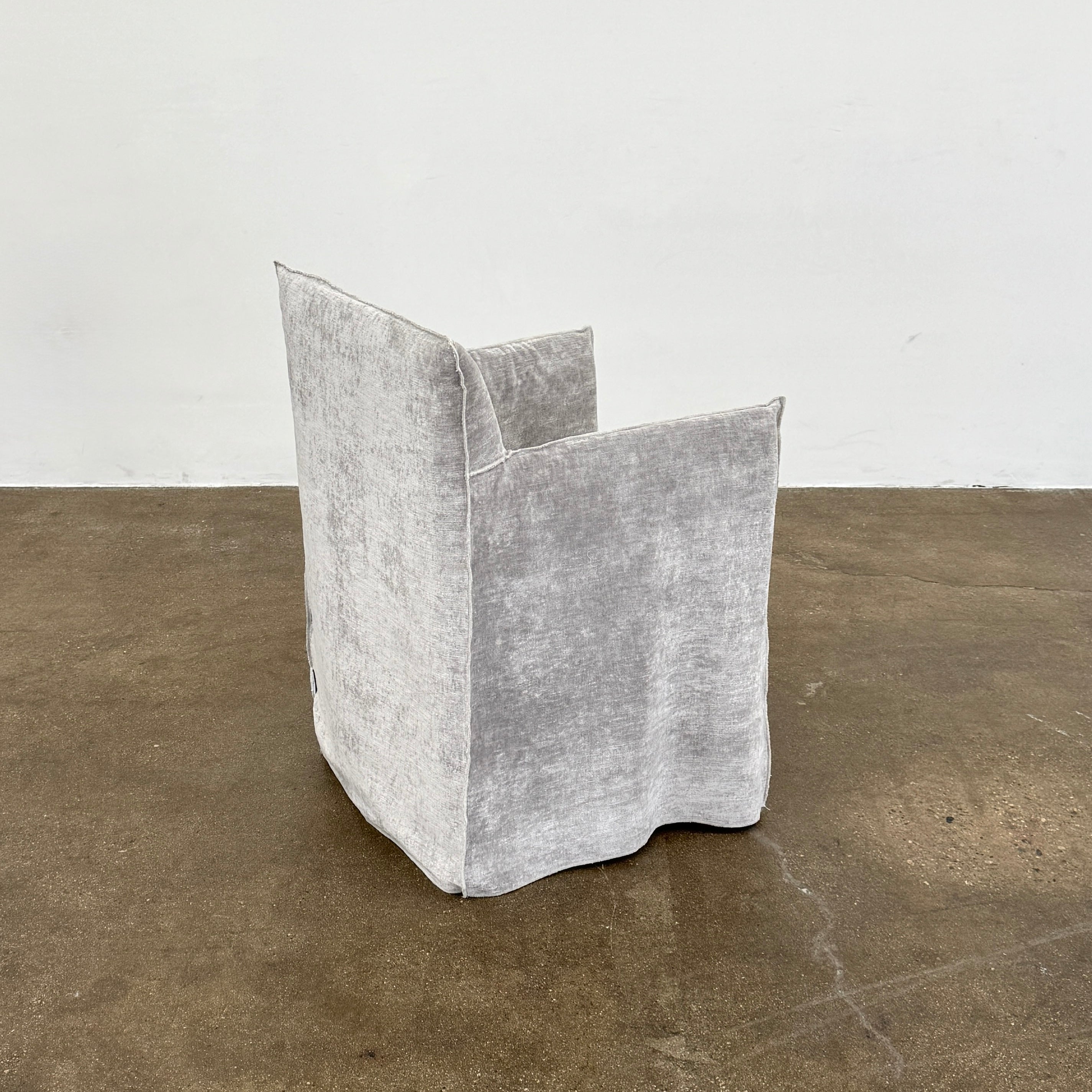 Four Gervasoni Ghost 25 Dining Armchairs by Gervasoni, featuring straight backs and skirted slipcovers in silver velvet, are arranged side by side against a white background for an elegant look.