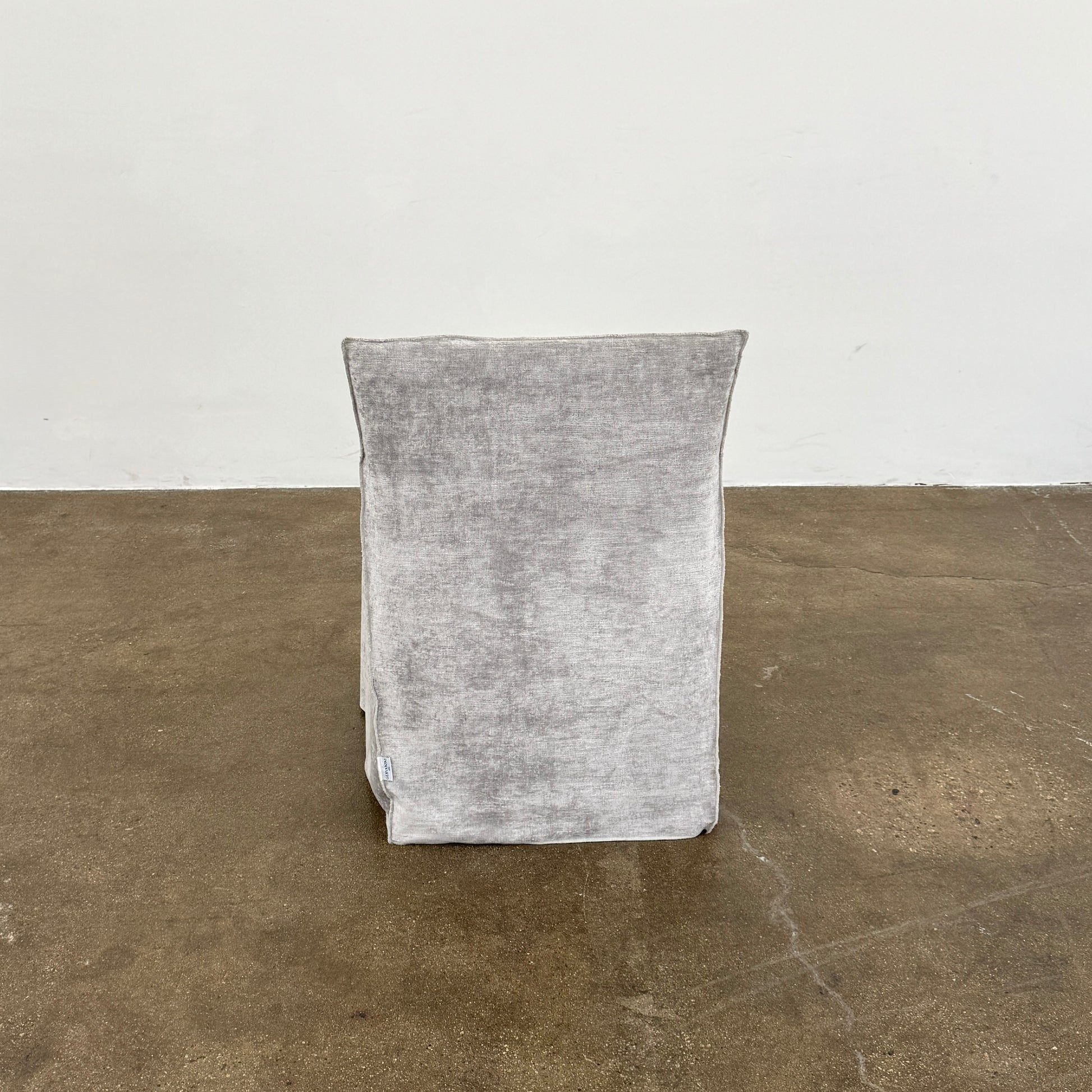 Four Gervasoni Ghost 25 Dining Armchairs by Gervasoni, featuring straight backs and skirted slipcovers in silver velvet, are arranged side by side against a white background for an elegant look.