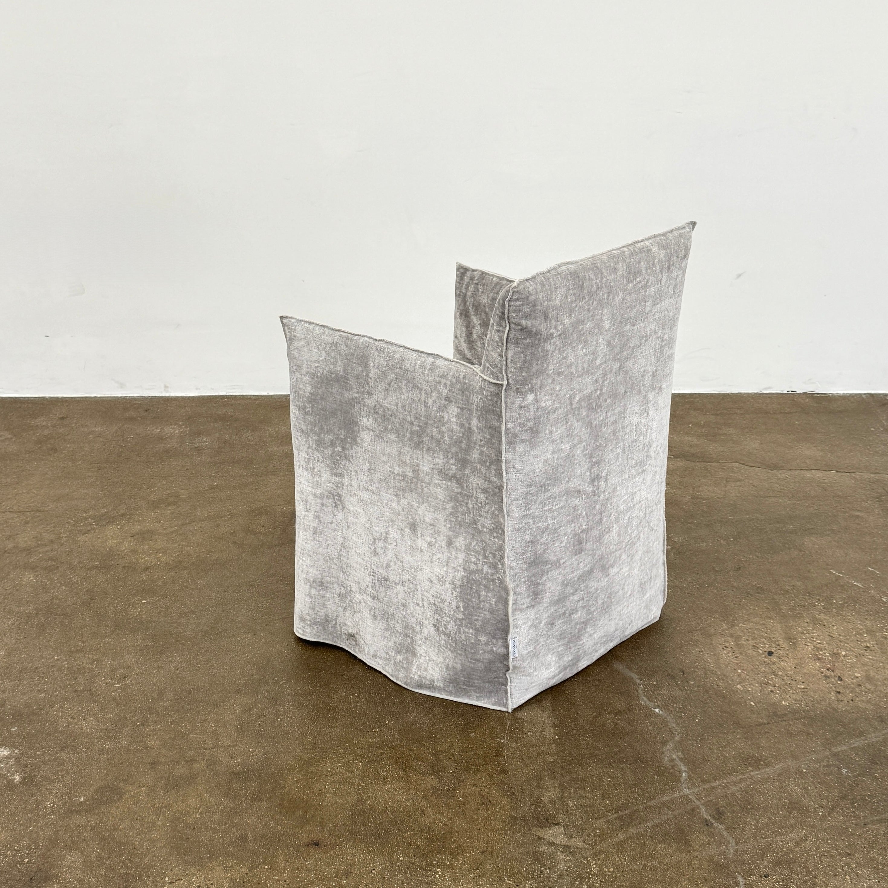 Four Gervasoni Ghost 25 Dining Armchairs by Gervasoni, featuring straight backs and skirted slipcovers in silver velvet, are arranged side by side against a white background for an elegant look.