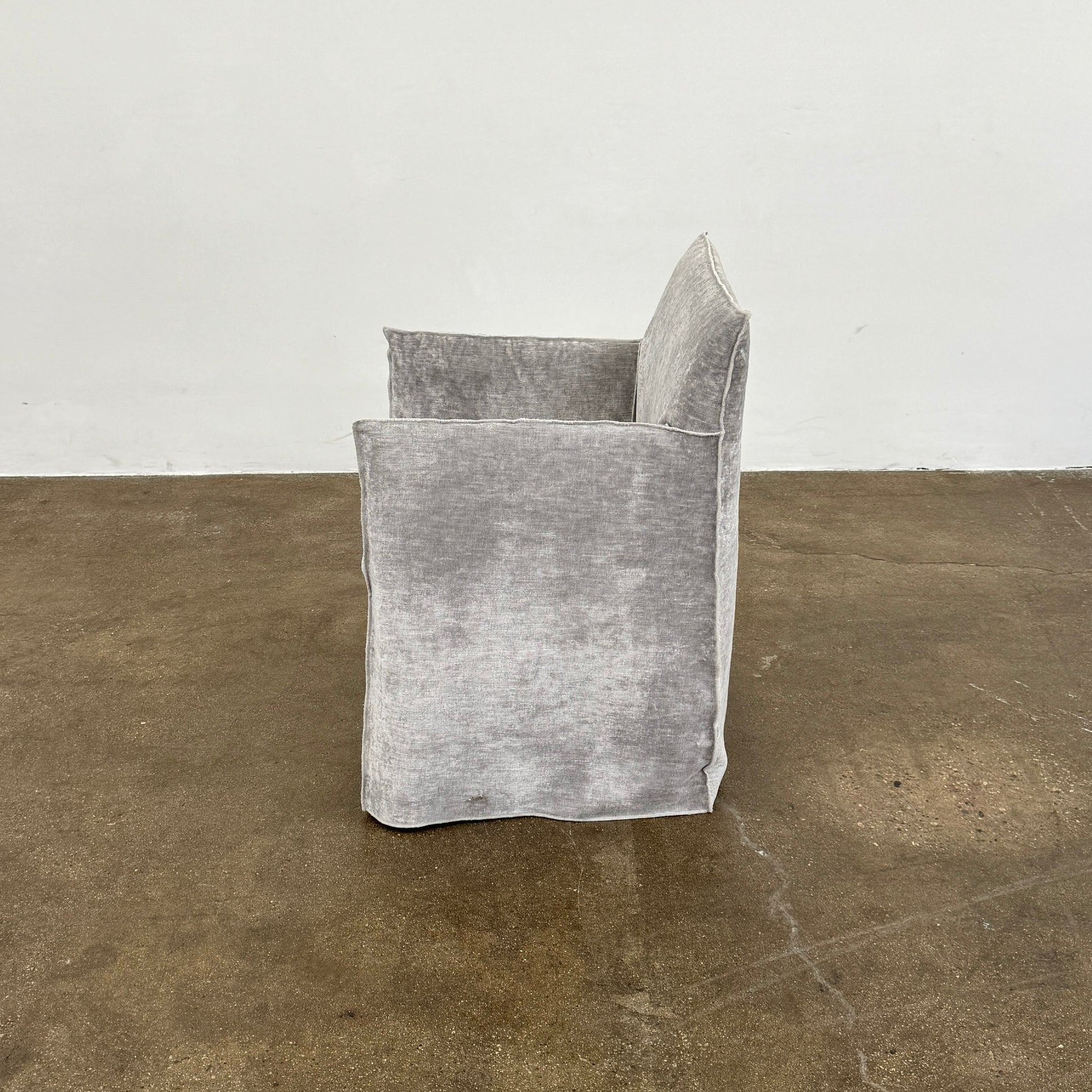 Four Gervasoni Ghost 25 Dining Armchairs by Gervasoni, featuring straight backs and skirted slipcovers in silver velvet, are arranged side by side against a white background for an elegant look.