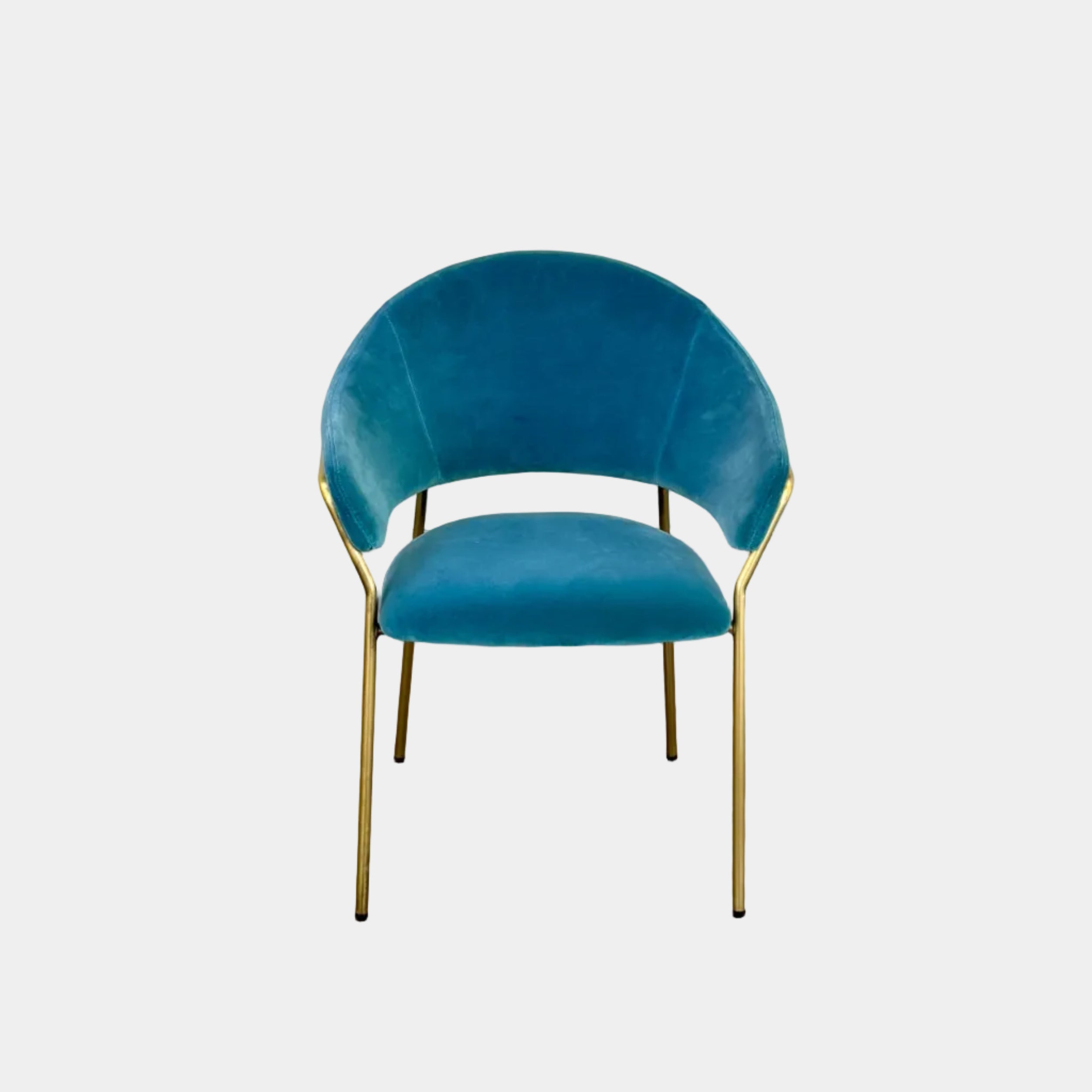Two Pedrali Jazz Chairs by Pedrali, featuring customizable teal velvet upholstery and gold metal legs, sit side by side on a concrete floor against a white wall, highlighting their stylish steel structure.