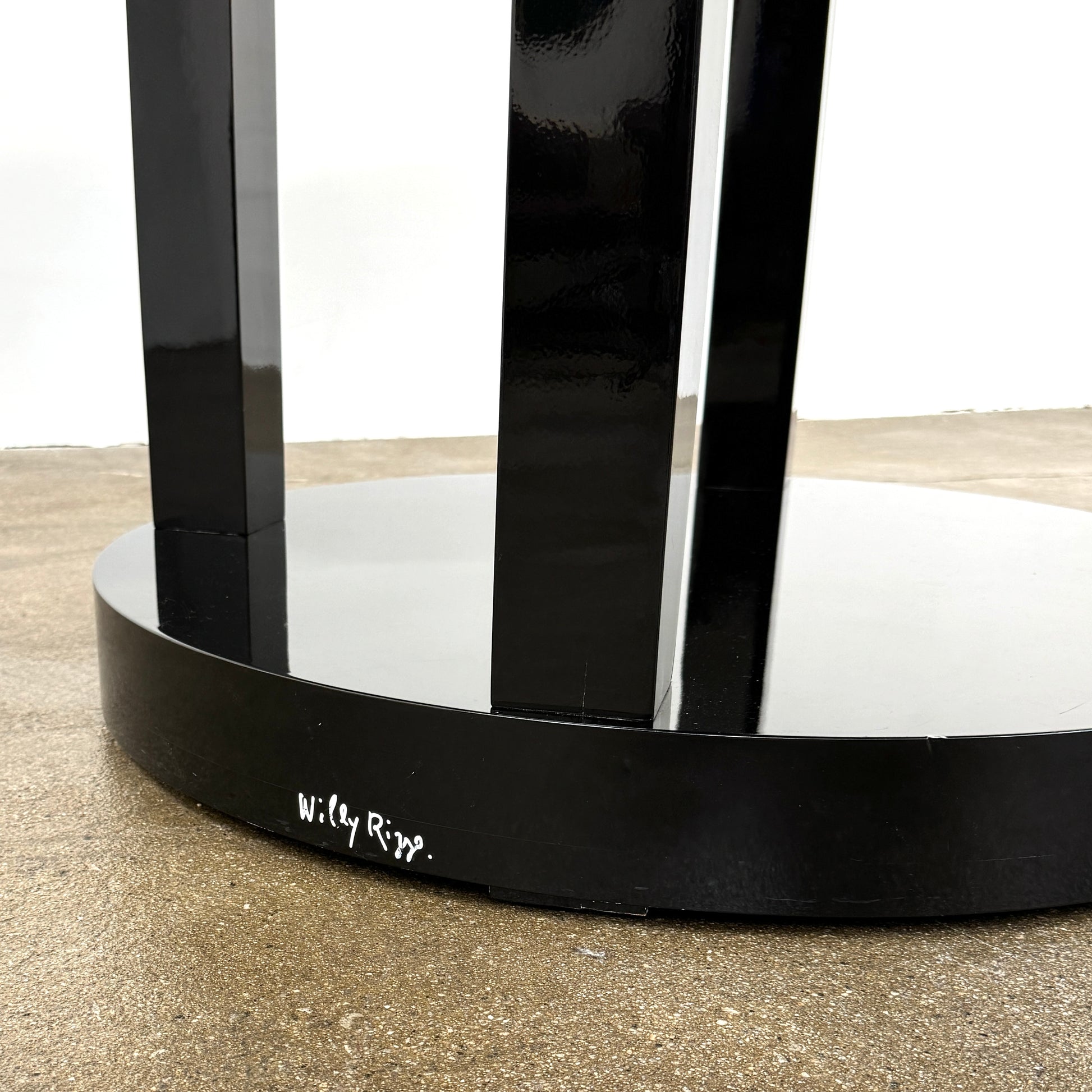 The Willy Rizzo Cassia Carello Dining Table features a round black lacquer top with a central revolving tray, set on a pedestal base with four vertical supports and a circular lower shelf, capturing the timeless Willy Rizzo design.