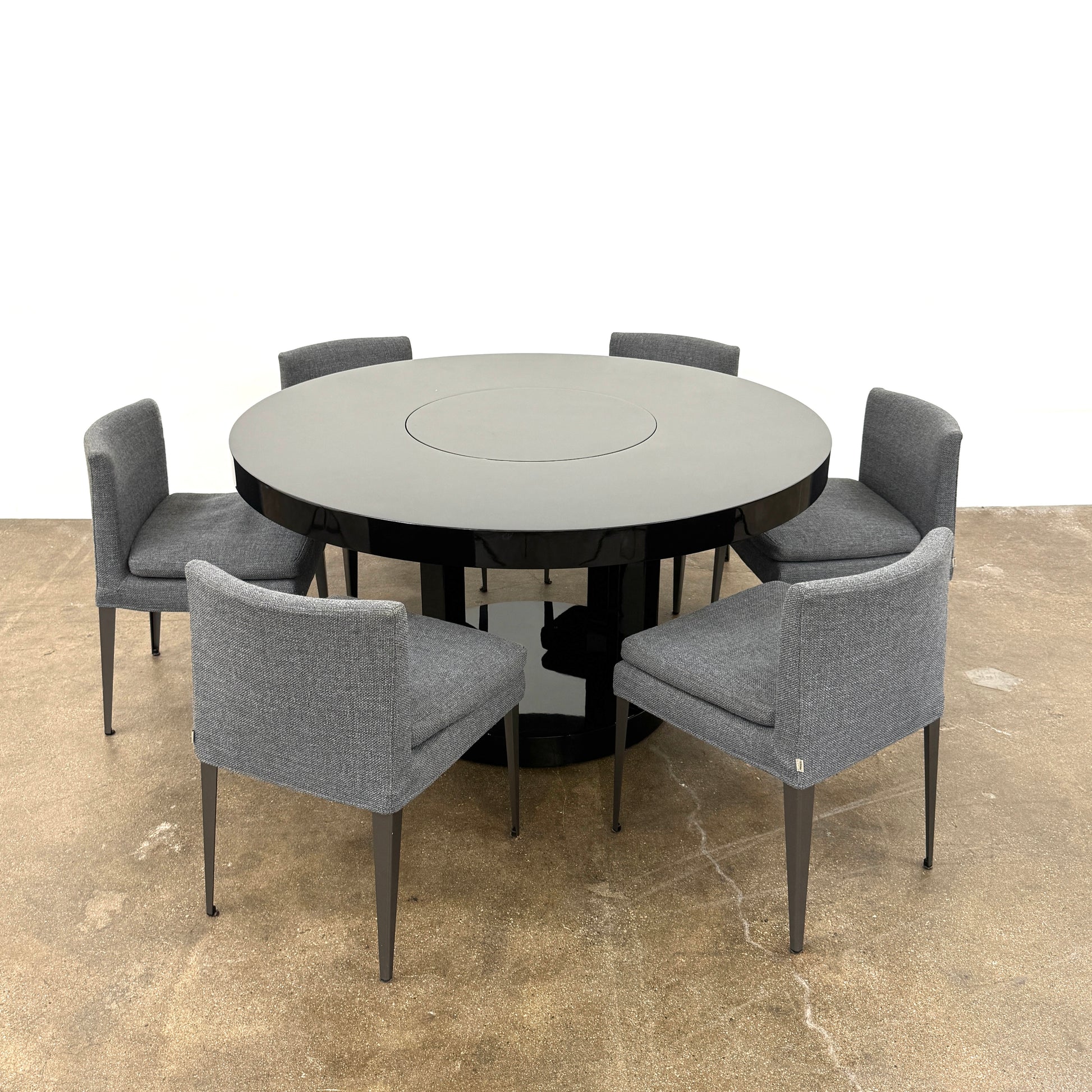 The Willy Rizzo Cassia Carello Dining Table features a round black lacquer top with a central revolving tray, set on a pedestal base with four vertical supports and a circular lower shelf, capturing the timeless Willy Rizzo design.
