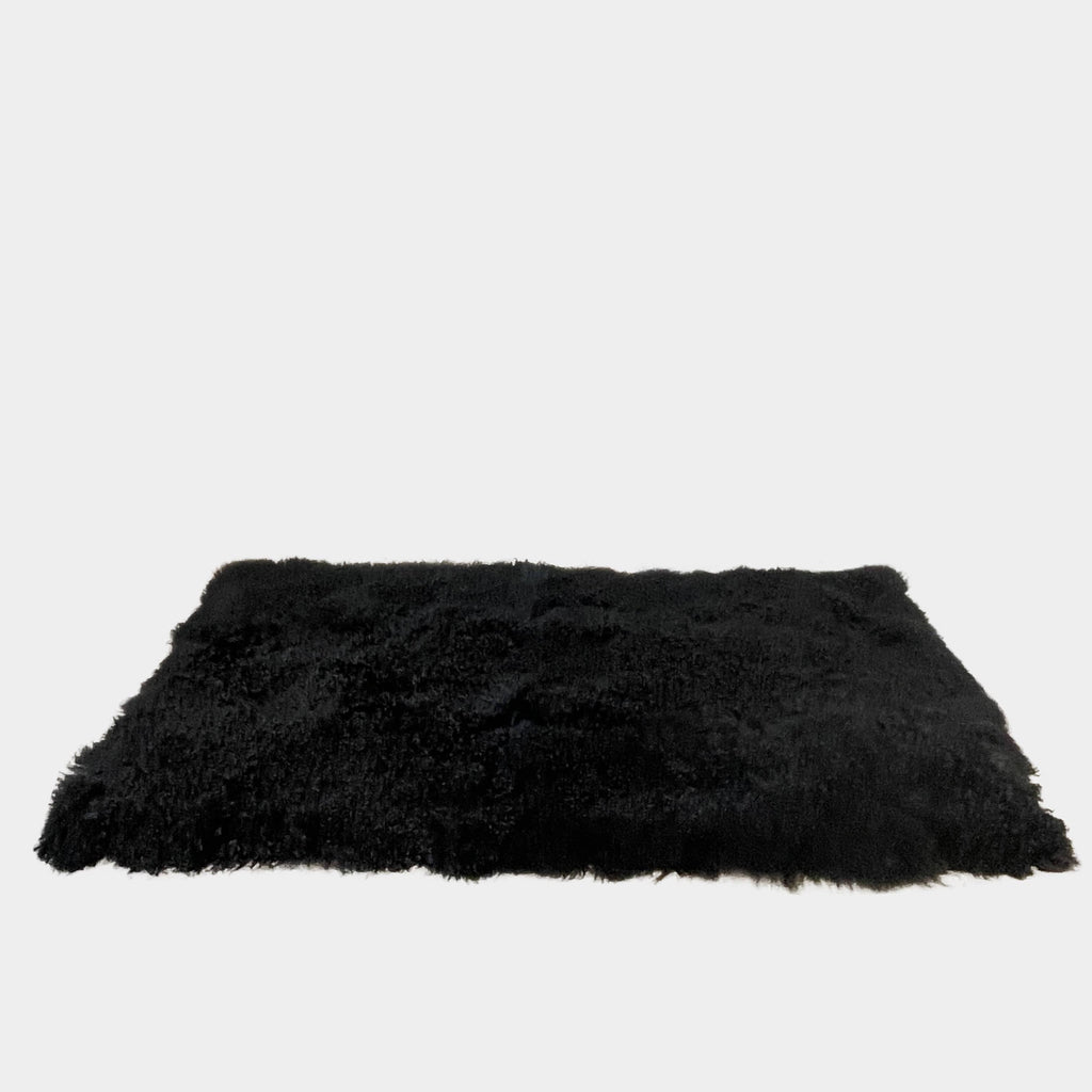 Black Icelandic Sheepskin 5' x 7' rug with a shaggy appearance against a white background.