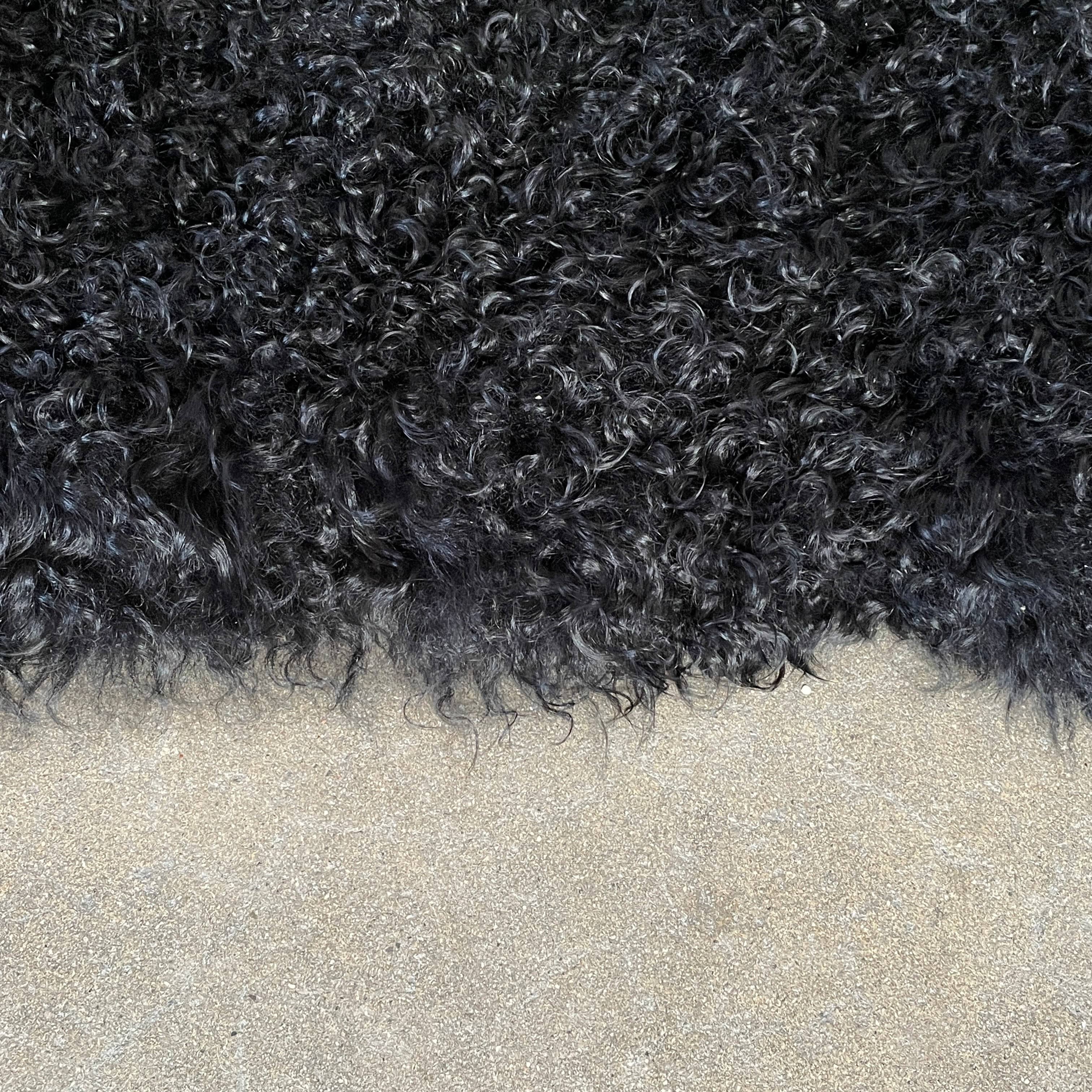 Black Icelandic Sheepskin 5' x 7' rug with a shaggy appearance against a white background.