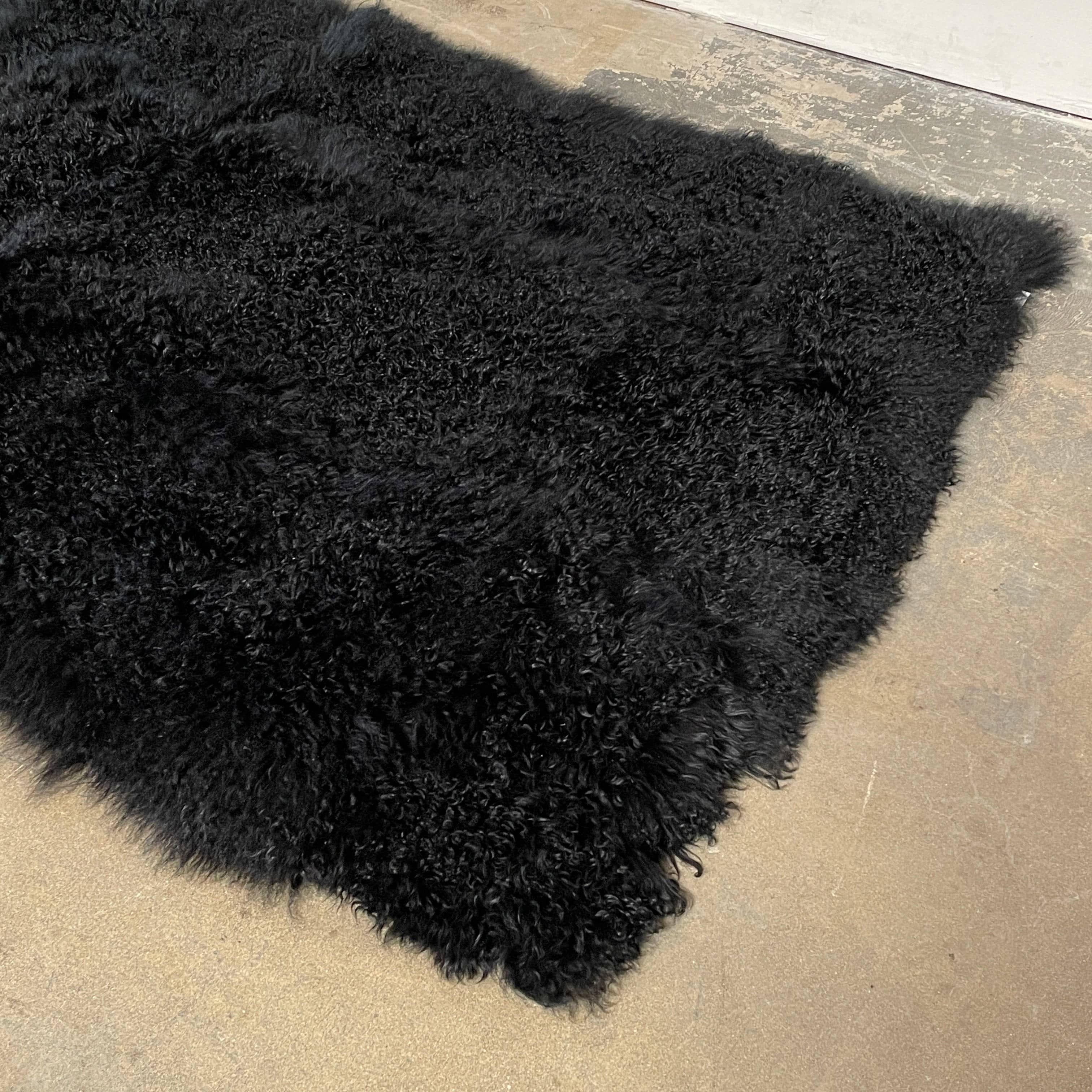Black Icelandic Sheepskin 5' x 7' rug with a shaggy appearance against a white background.