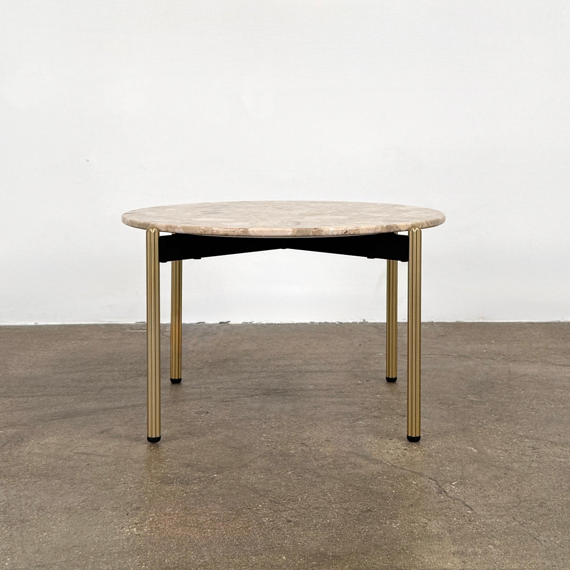 The Pedrali Blume Side Table features a round top and elegant gold legs, offering a stylish addition to any room.