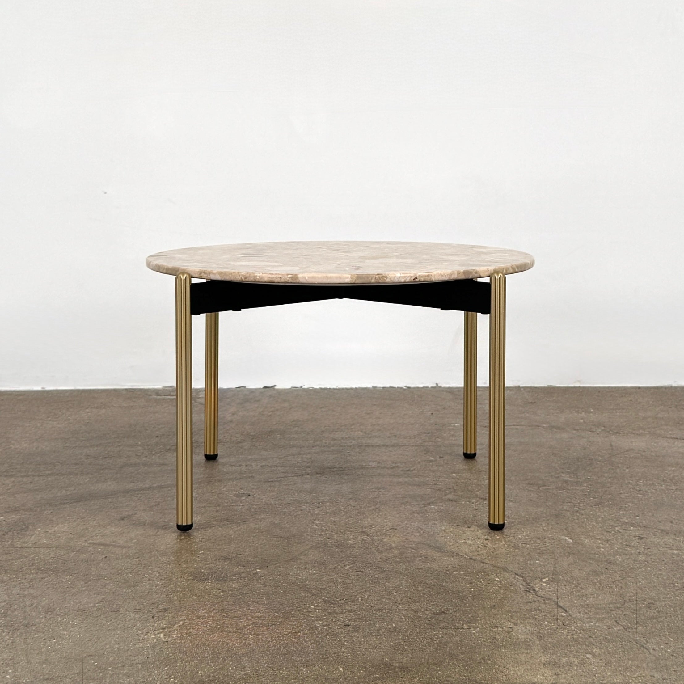 The Pedrali Blume Side Table features a round top and elegant gold legs, offering a stylish addition to any room.