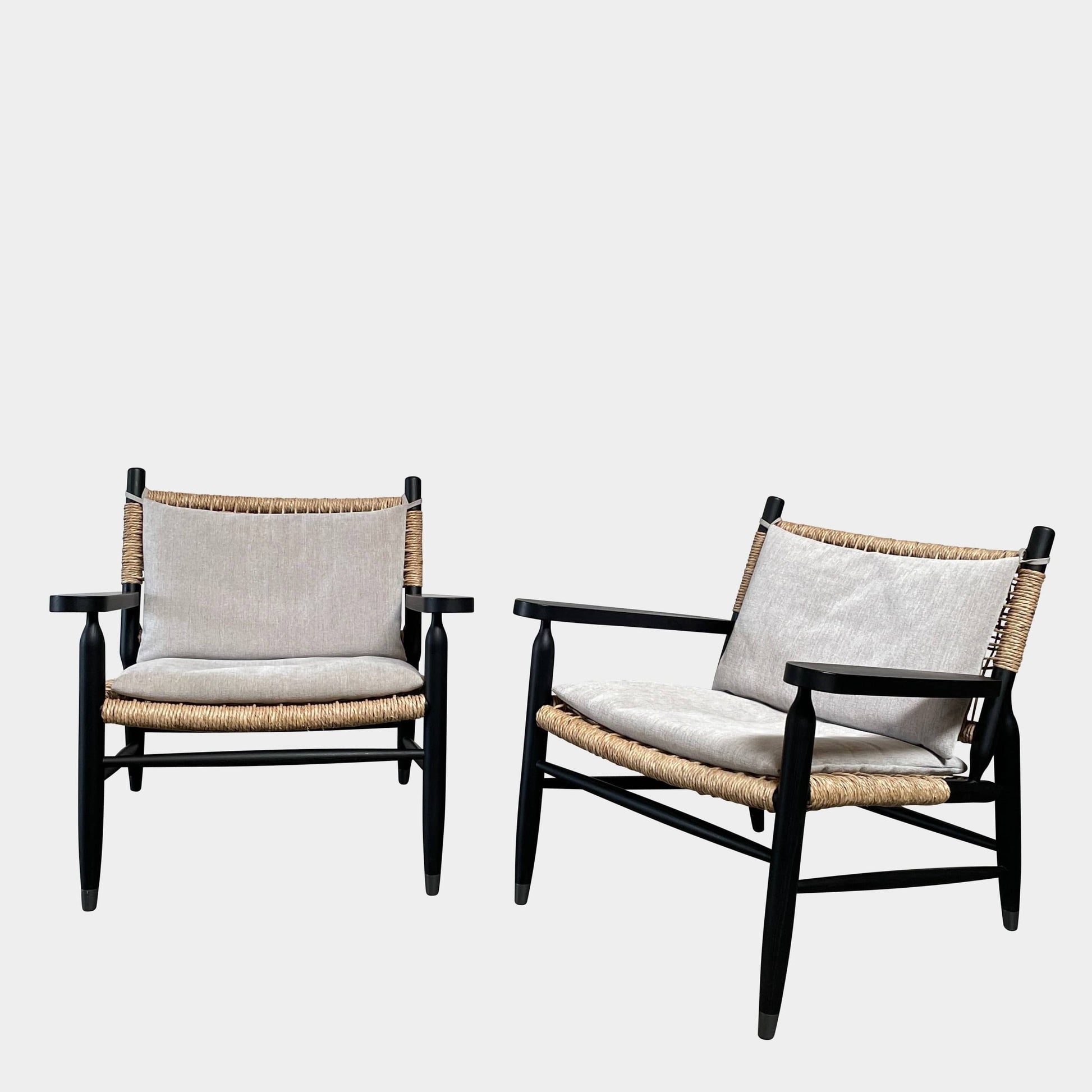 Two hand-crafted Flexform Tessa Lounge Chairs with black frames and neutral-tone cushions on a white background.