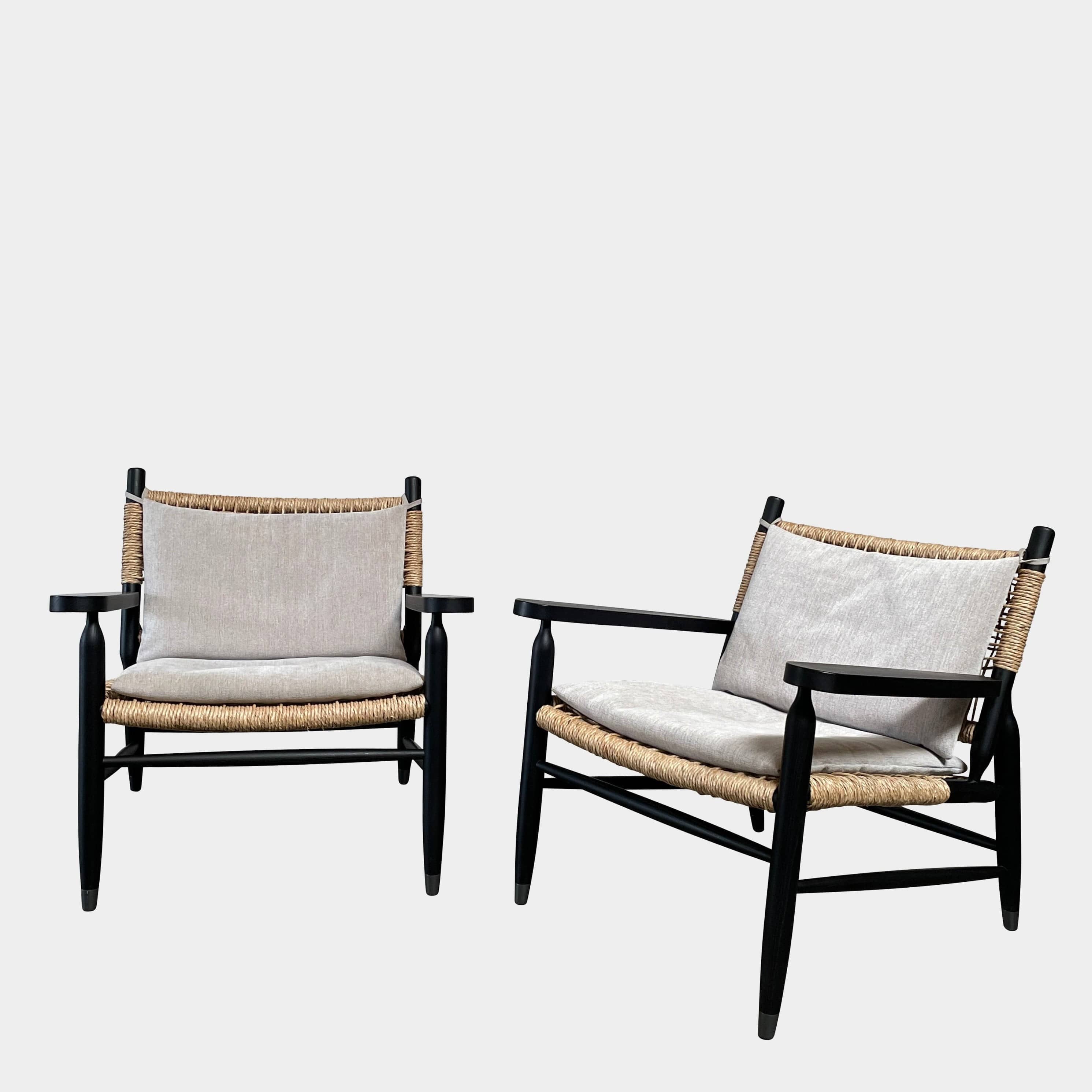 Two hand-crafted Flexform Tessa Lounge Chairs with black frames and neutral-tone cushions on a white background.