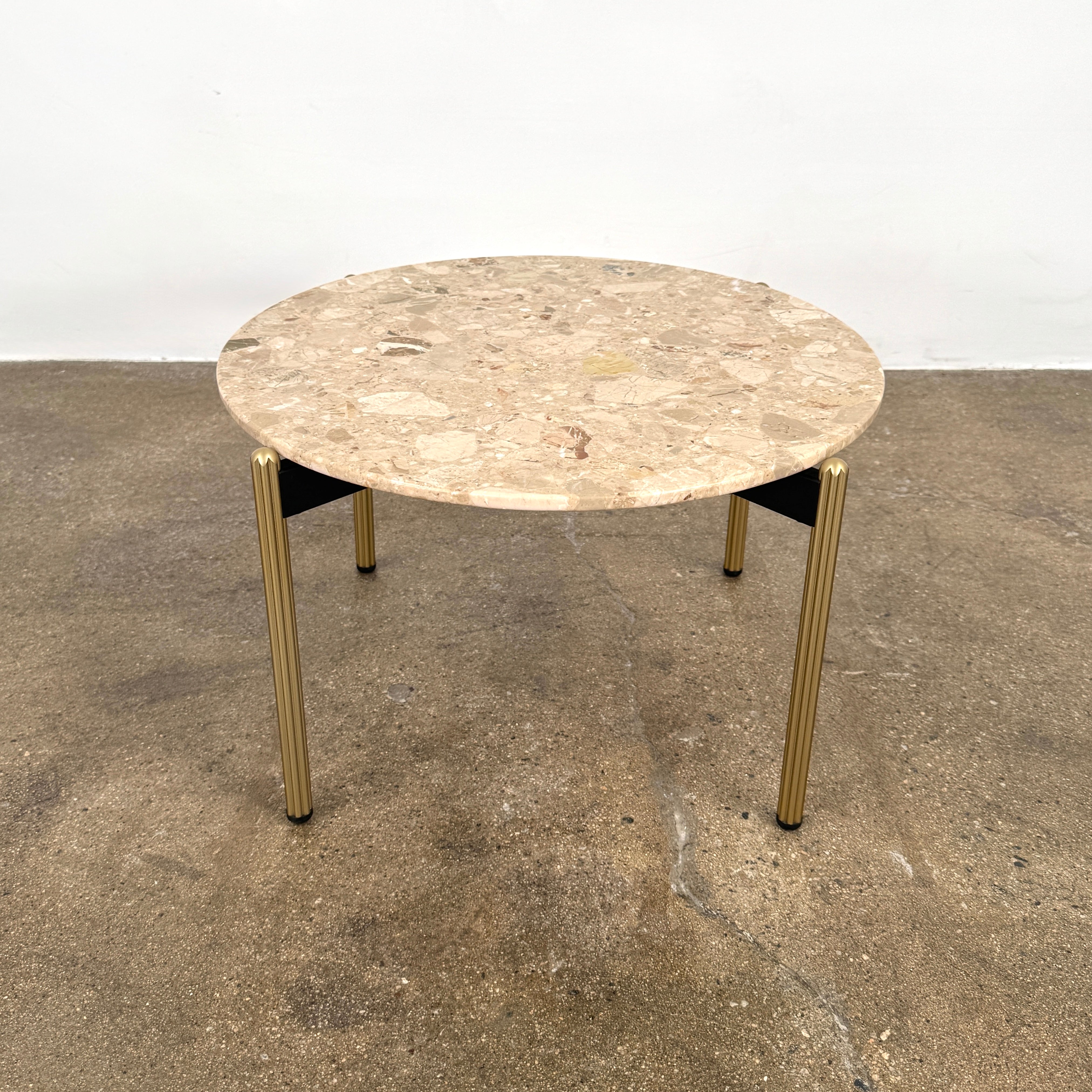 The Pedrali Blume Side Table features a round top and elegant gold legs, offering a stylish addition to any room.