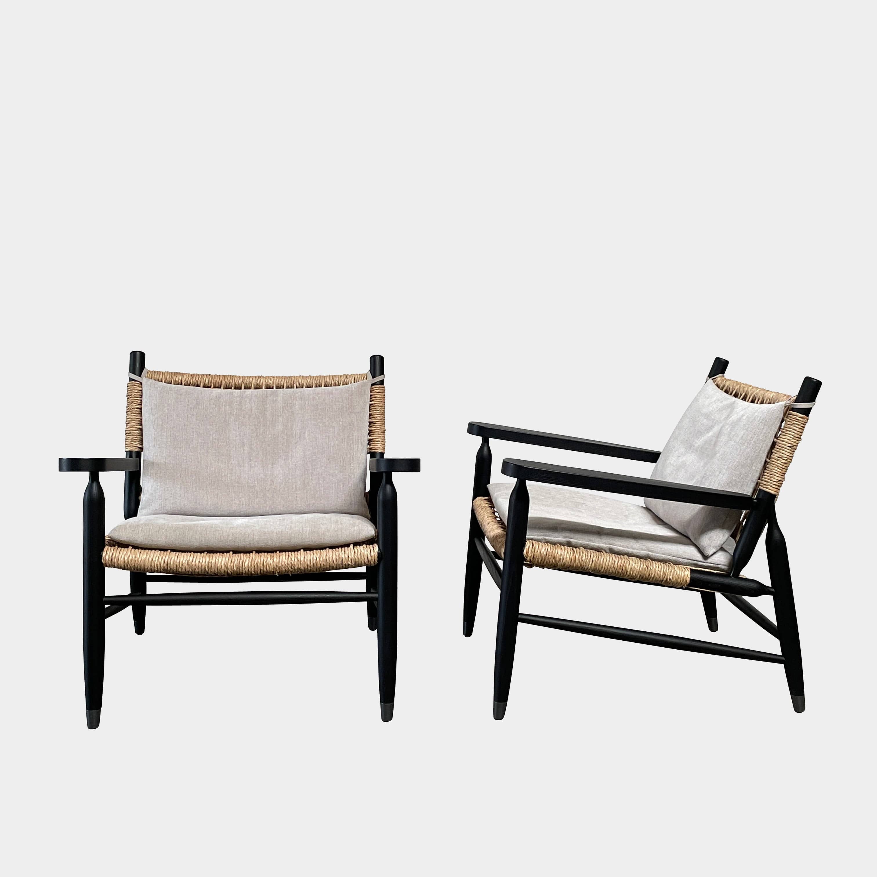 Two hand-crafted Flexform Tessa Lounge Chairs with black frames and neutral-tone cushions on a white background.