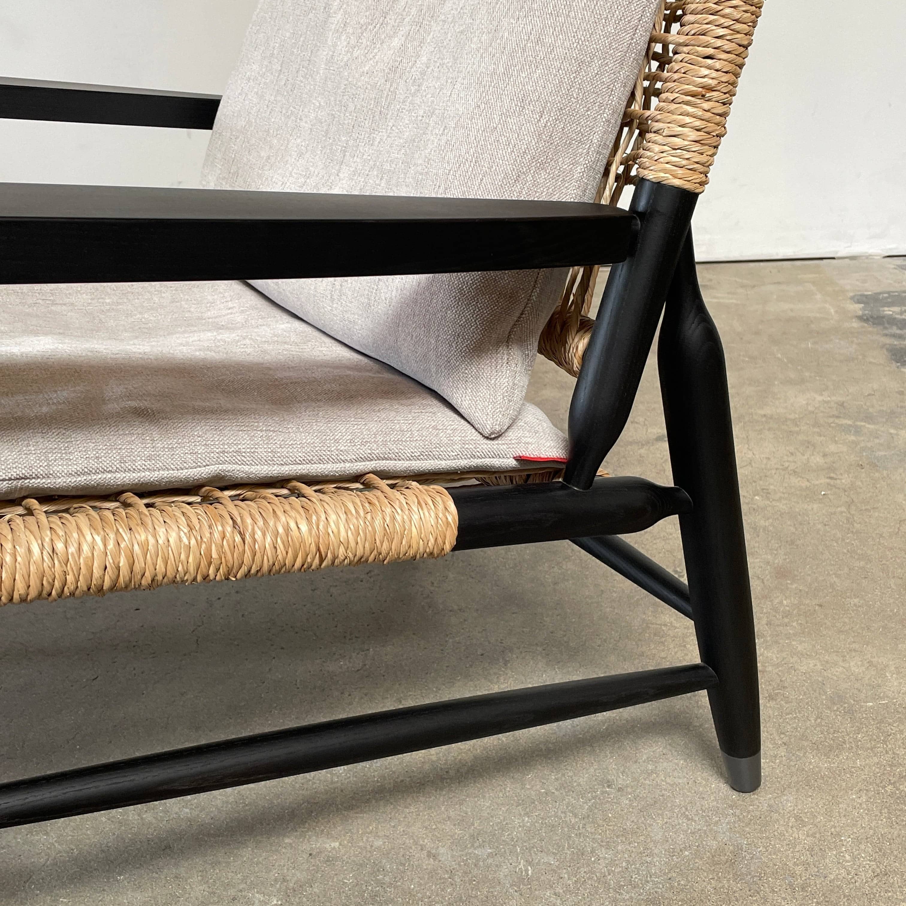 Two hand-crafted Flexform Tessa Lounge Chairs with black frames and neutral-tone cushions on a white background.