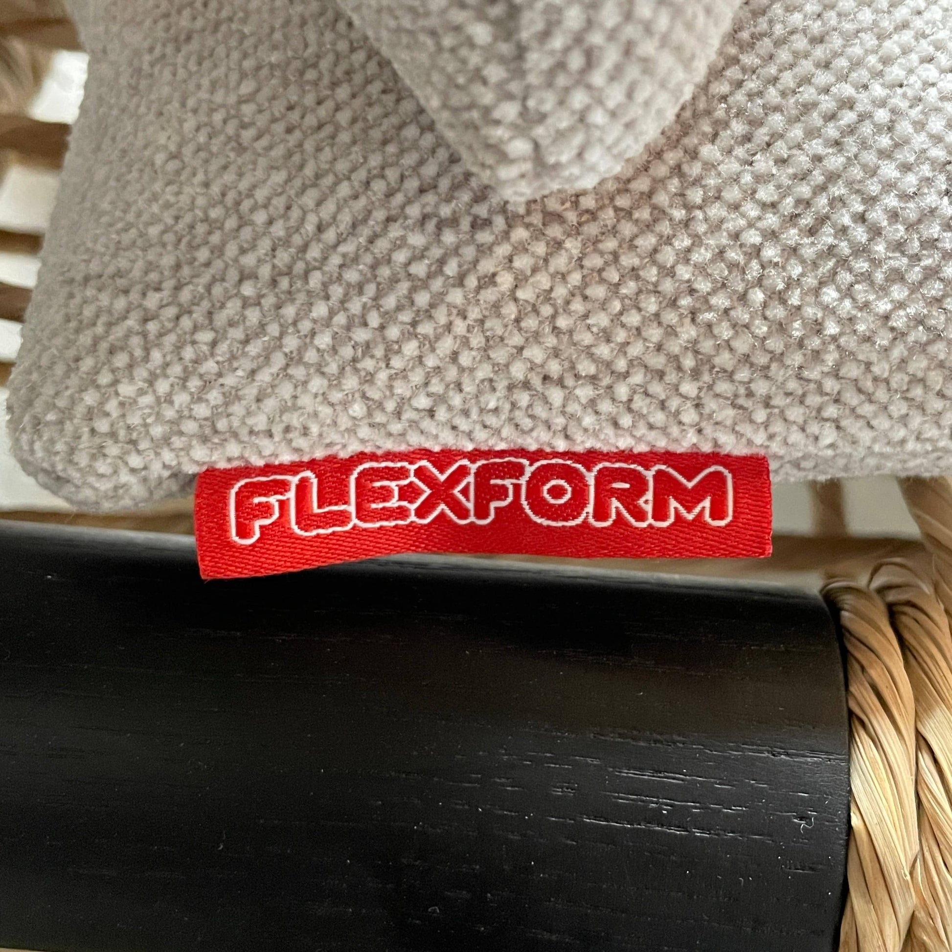 Two hand-crafted Flexform Tessa Lounge Chairs with black frames and neutral-tone cushions on a white background.