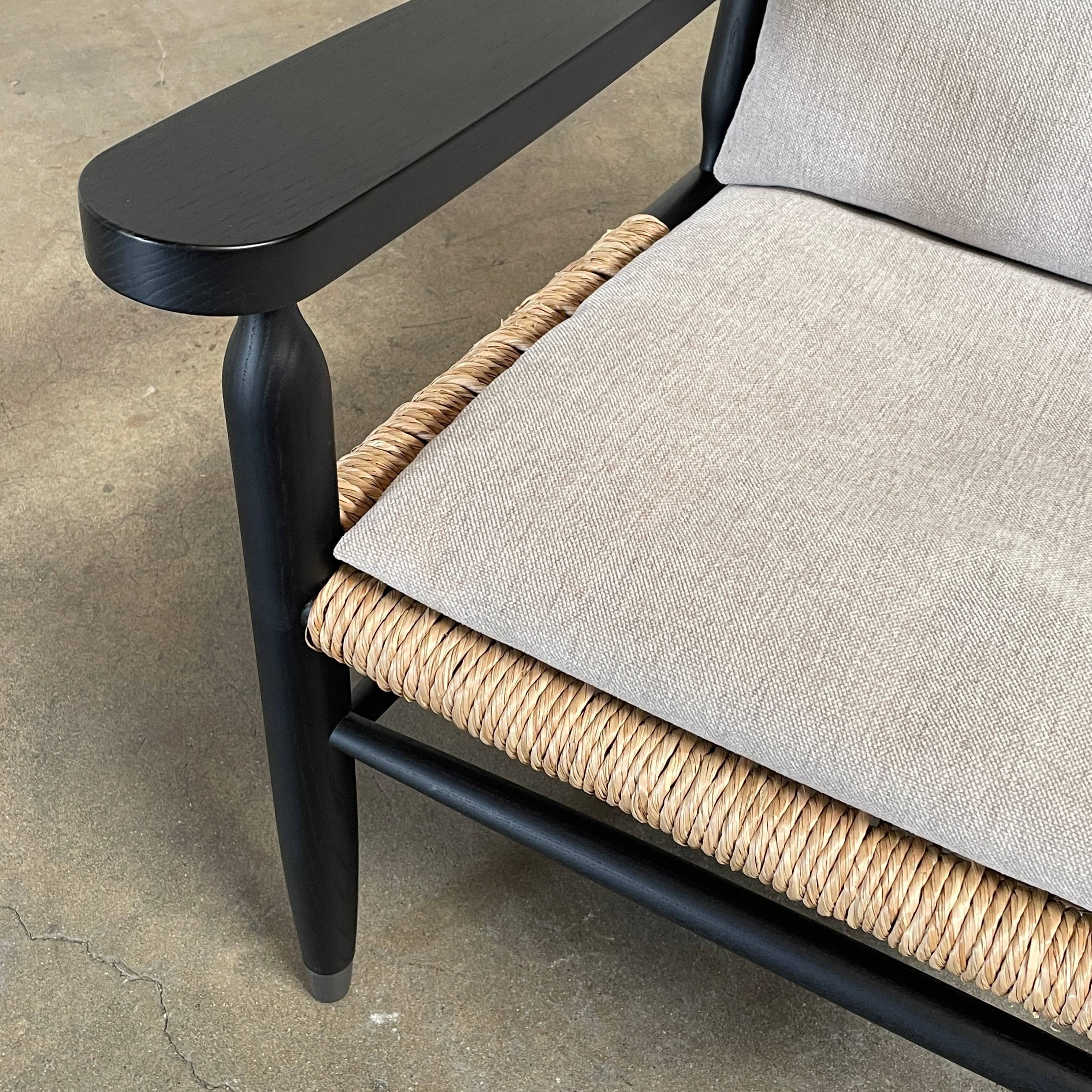 Two hand-crafted Flexform Tessa Lounge Chairs with black frames and neutral-tone cushions on a white background.