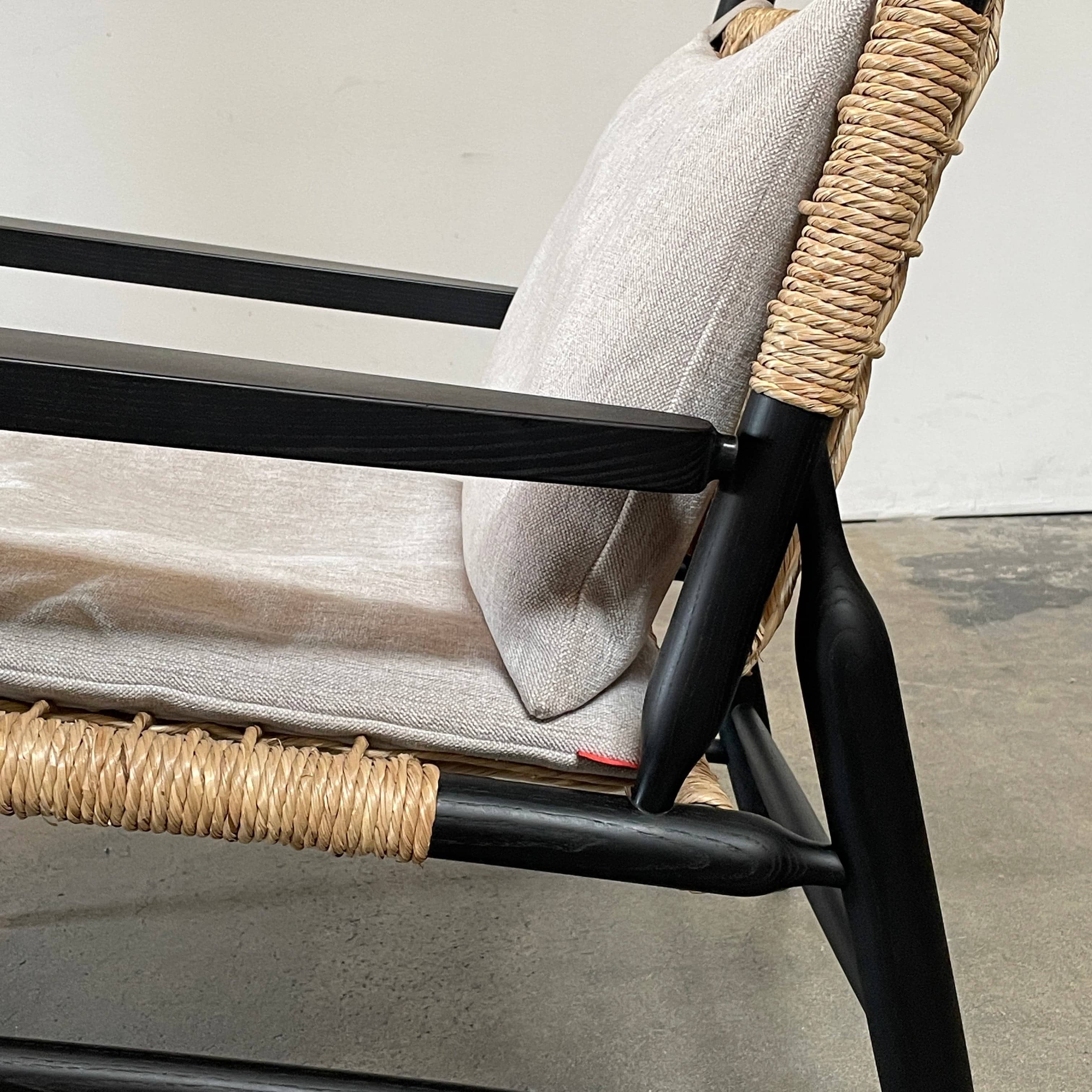 Two hand-crafted Flexform Tessa Lounge Chairs with black frames and neutral-tone cushions on a white background.