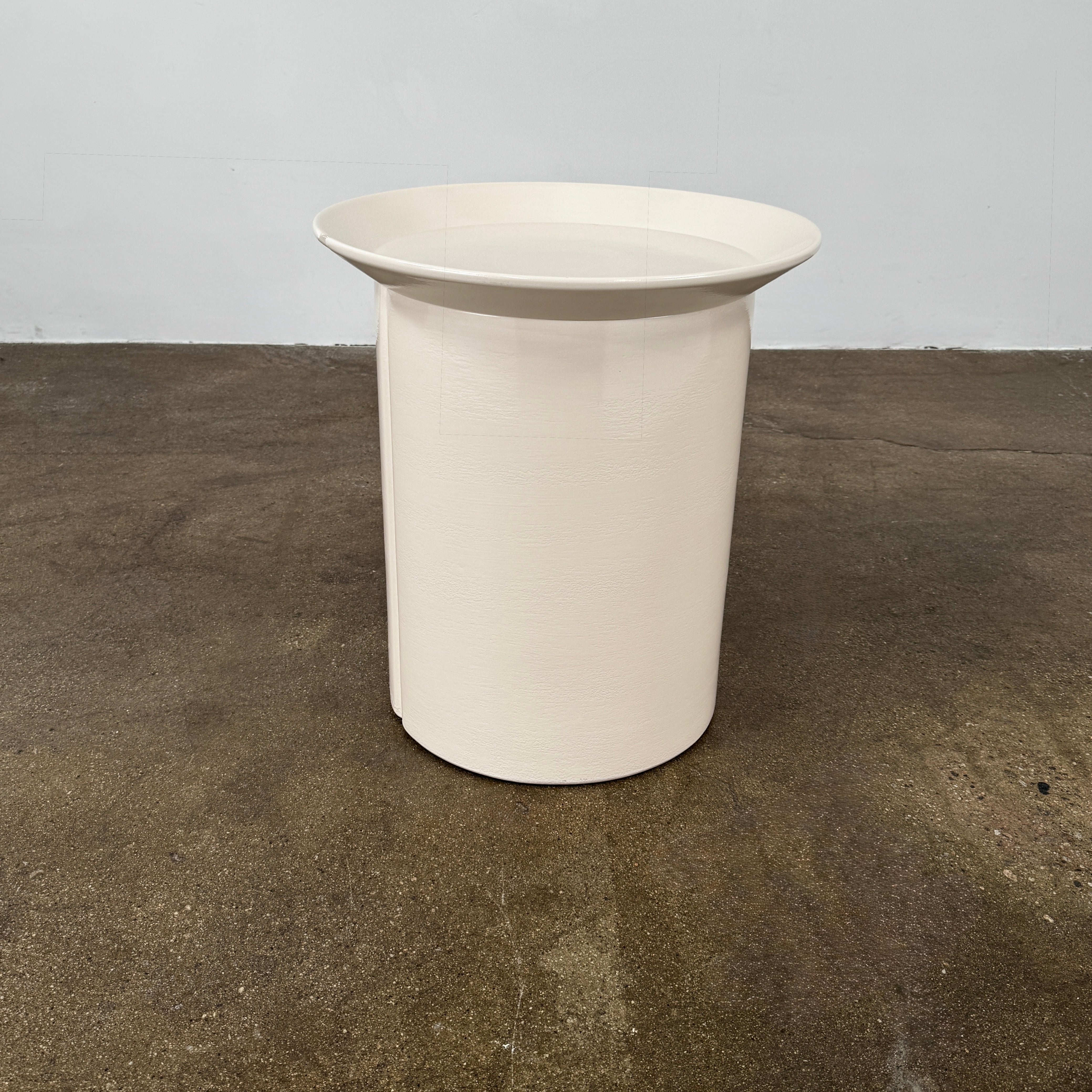 The Gervasoni Brise 43 Side Table by Gervasoni features a beige, cylindrical shape with a wide, subtly flared rim and a vertical seam, evoking Art Nouveau influences, shown against a plain white background.