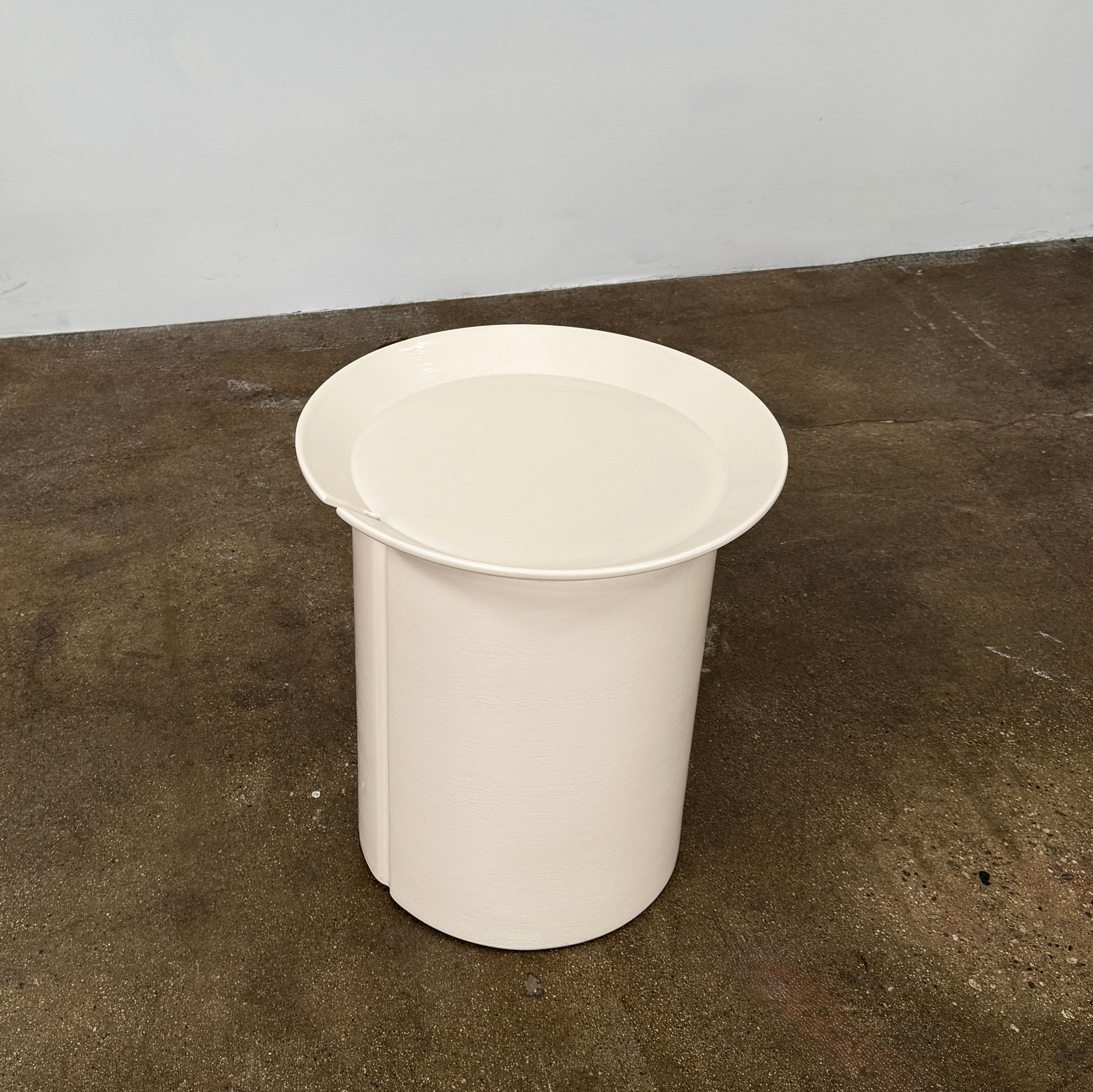 The Gervasoni Brise 43 Side Table by Gervasoni features a beige, cylindrical shape with a wide, subtly flared rim and a vertical seam, evoking Art Nouveau influences, shown against a plain white background.