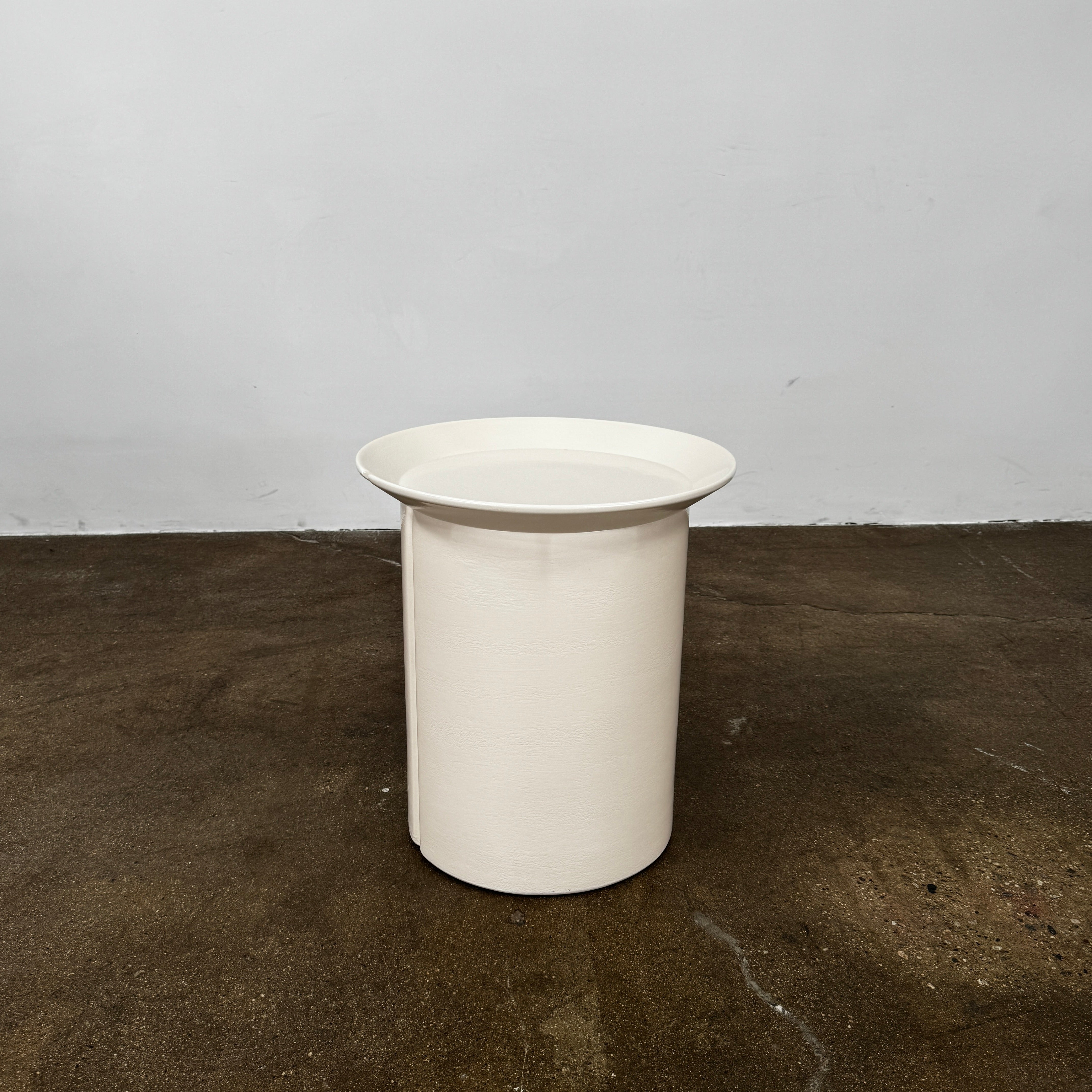 The Gervasoni Brise 43 Side Table by Gervasoni features a beige, cylindrical shape with a wide, subtly flared rim and a vertical seam, evoking Art Nouveau influences, shown against a plain white background.