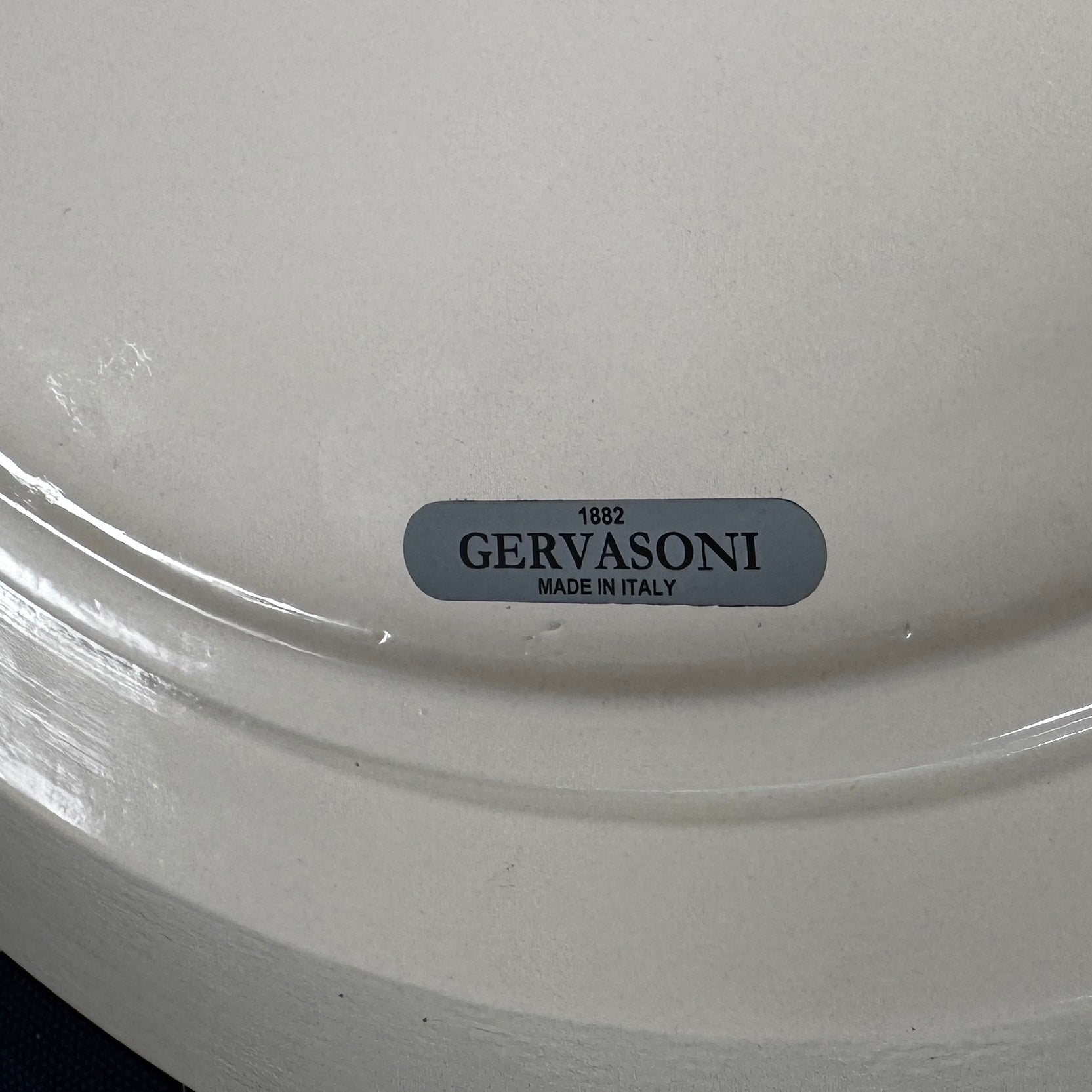 The Gervasoni Brise 43 Side Table by Gervasoni features a beige, cylindrical shape with a wide, subtly flared rim and a vertical seam, evoking Art Nouveau influences, shown against a plain white background.