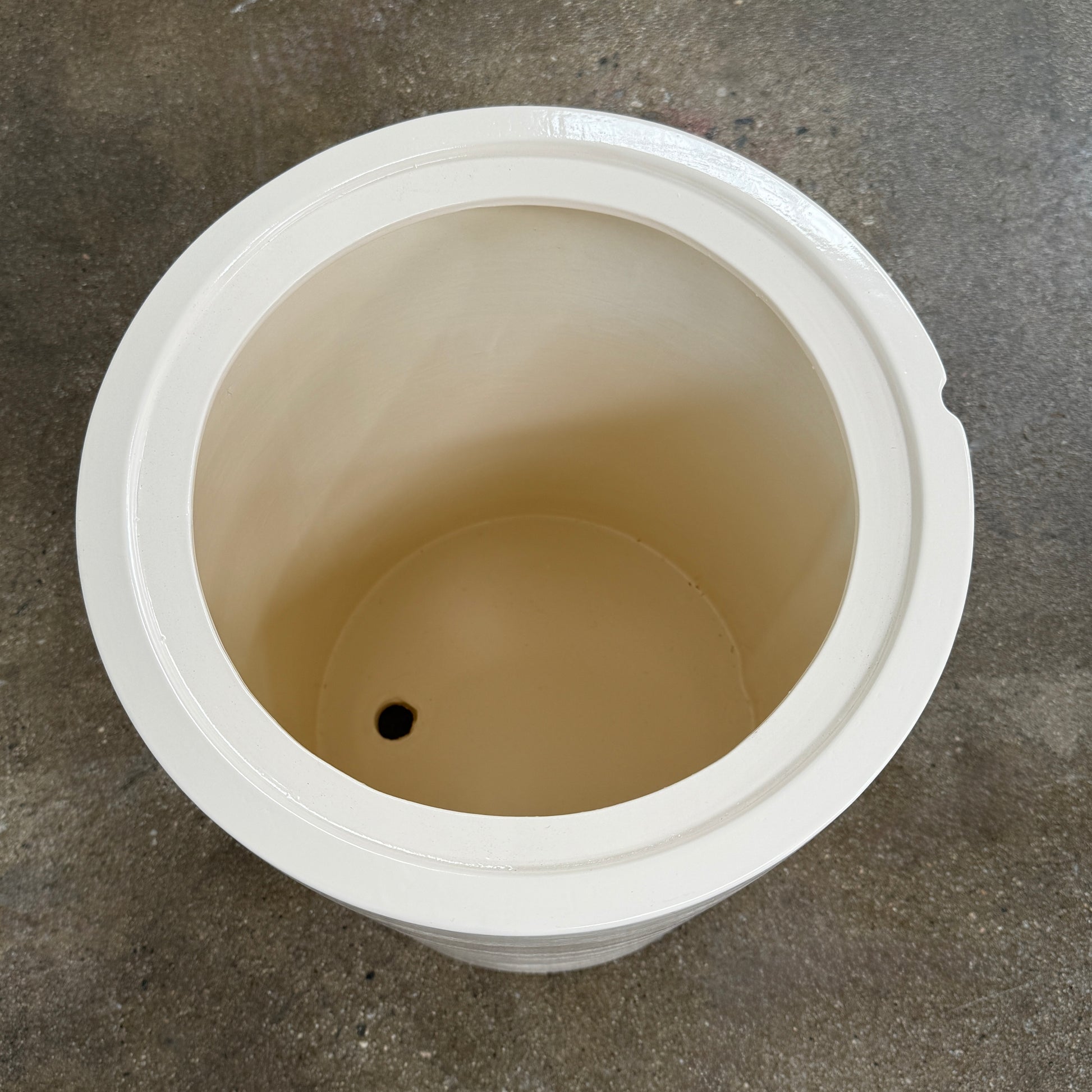 The Gervasoni Brise 43 Side Table by Gervasoni features a beige, cylindrical shape with a wide, subtly flared rim and a vertical seam, evoking Art Nouveau influences, shown against a plain white background.