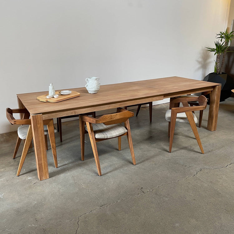 An Ethnicraft Slice Extendable Dining Table on a white background.