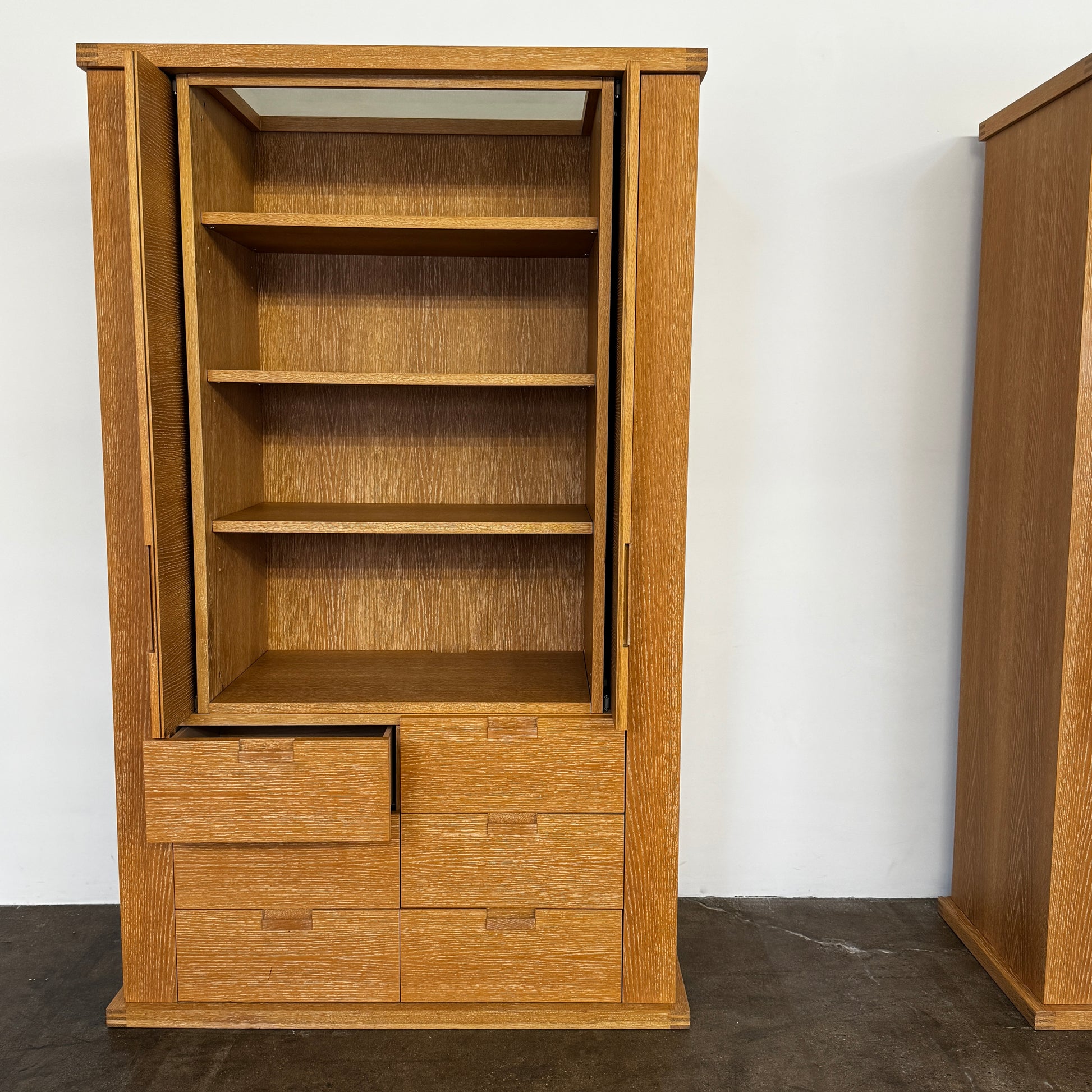 The Maxalto Apta Storage Unit by Maxalto features two vertical doors above and four bottom drawers in two rows, providing versatile storage with convenient shelves and drawers.