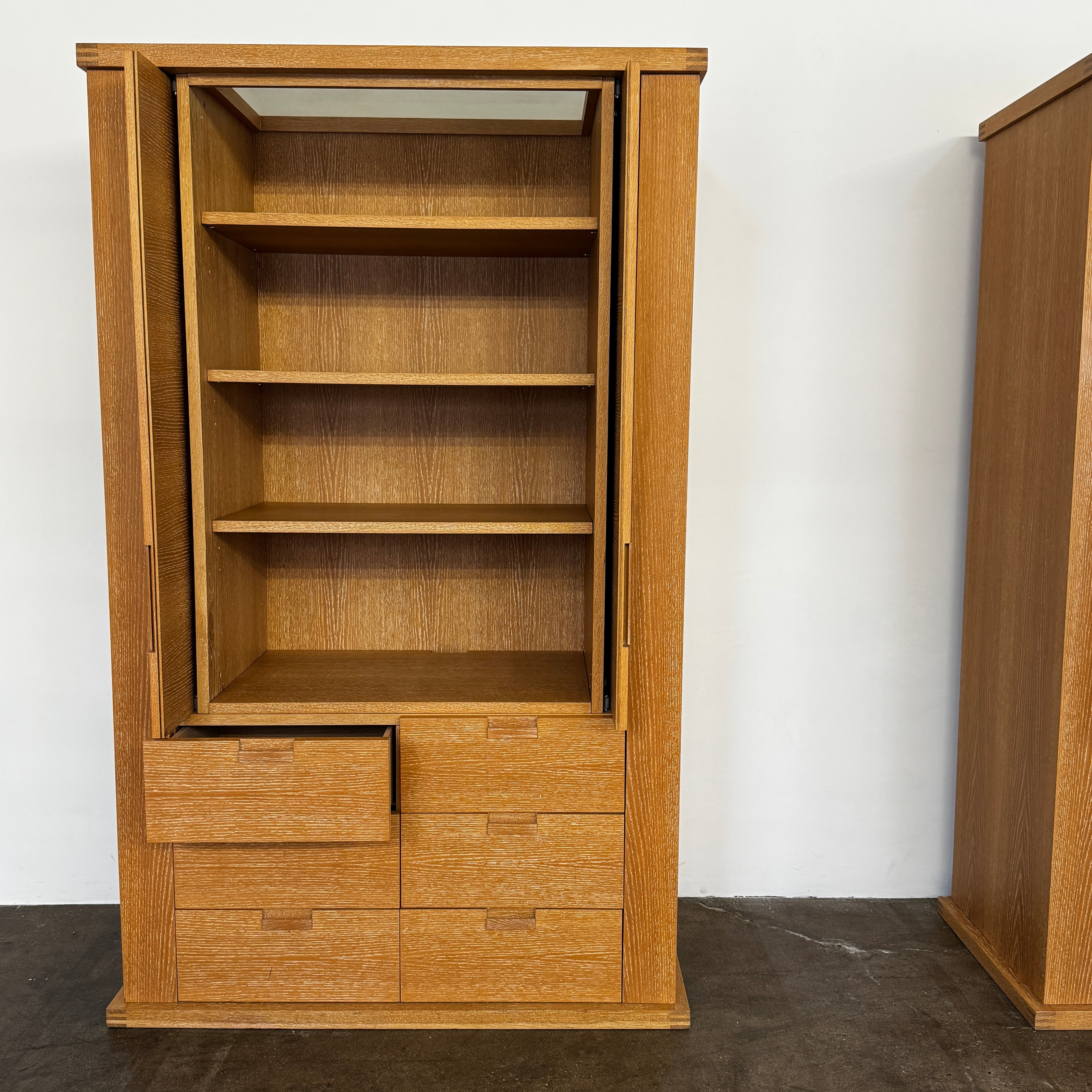 The Maxalto Apta Storage Unit by Maxalto features two vertical doors above and four bottom drawers in two rows, providing versatile storage with convenient shelves and drawers.