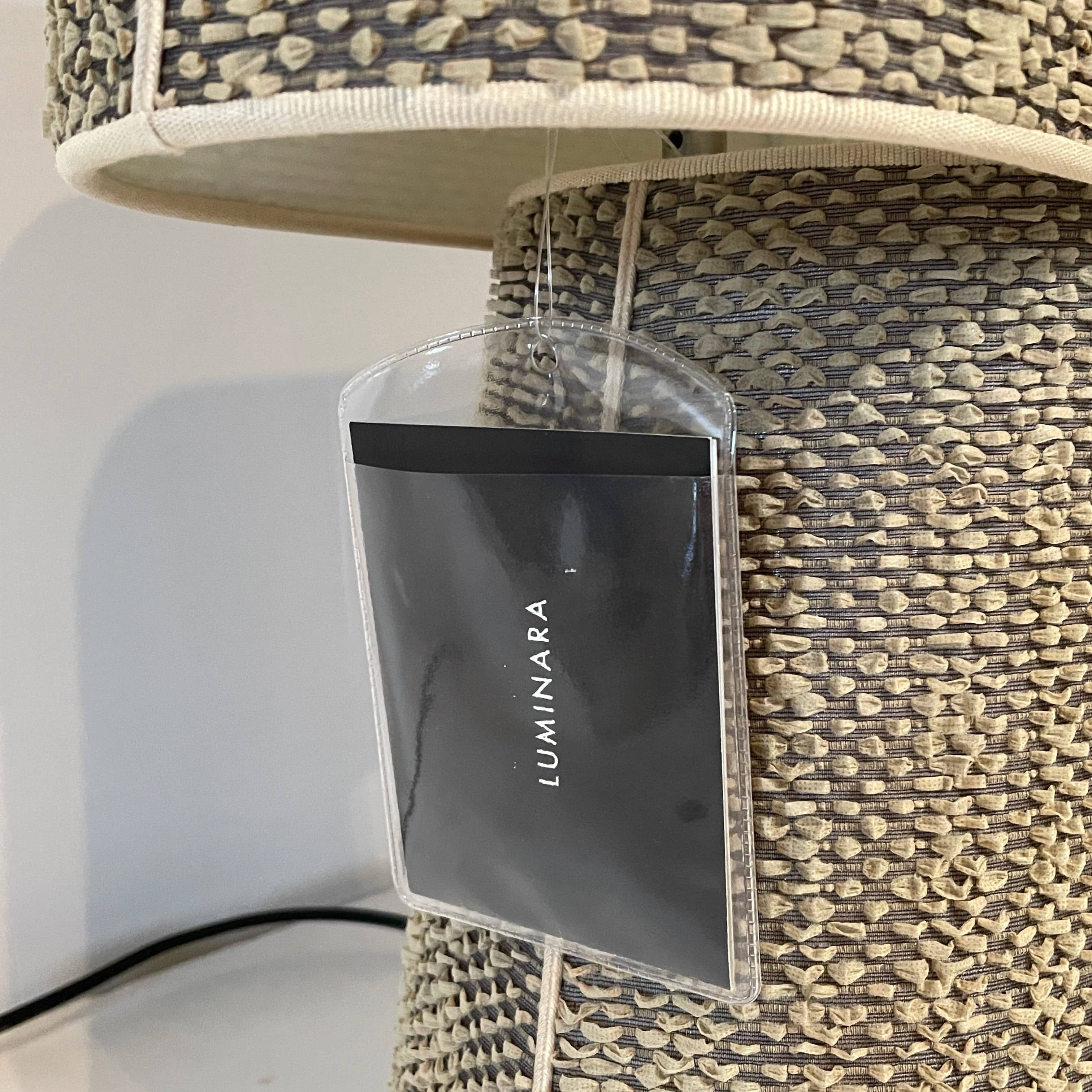 Two-tiered, textured fabric lampshade with a loop finial on a white background for the Luminara Dabliu Table Light by Luminara.