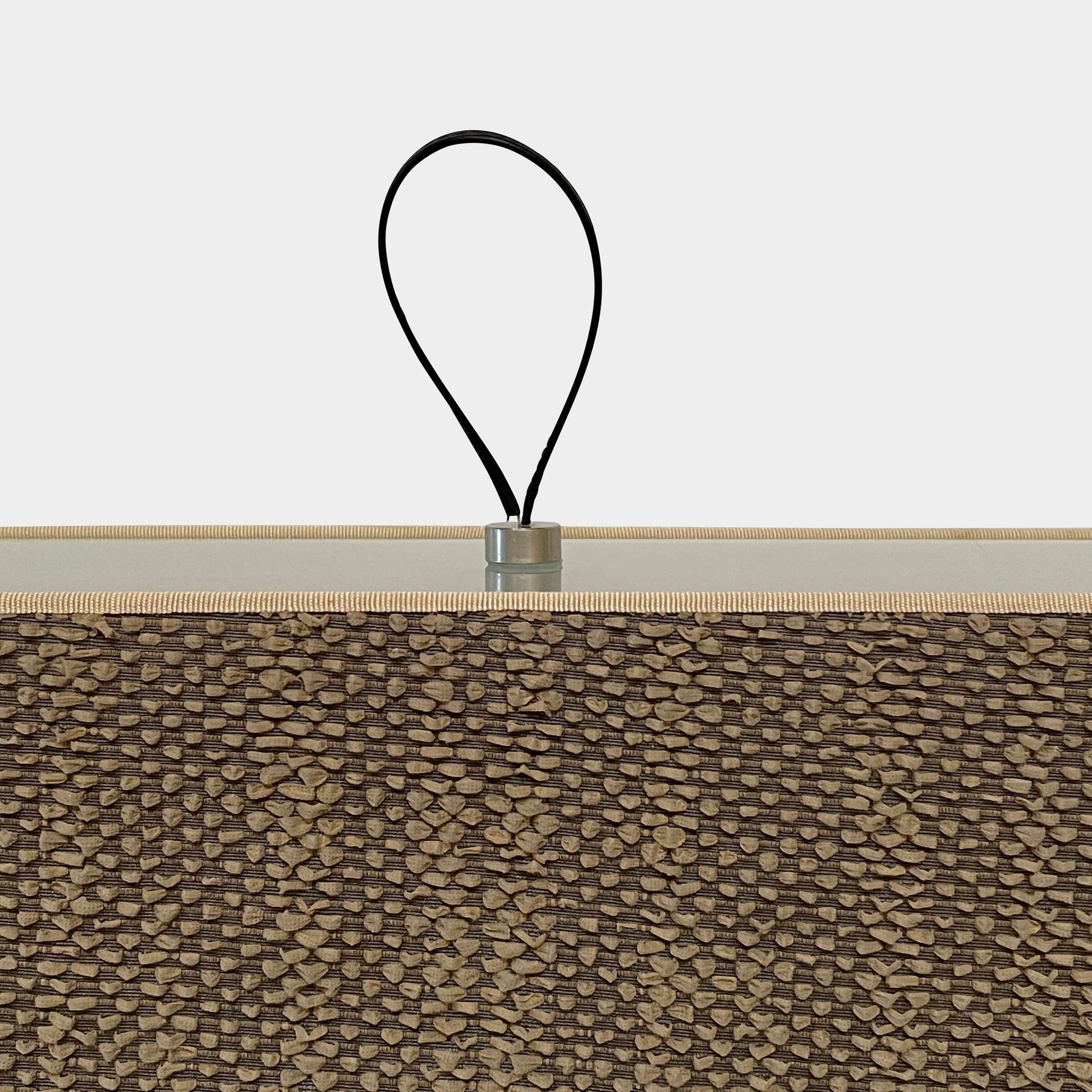 Two-tiered, textured fabric lampshade with a loop finial on a white background for the Luminara Dabliu Table Light by Luminara.