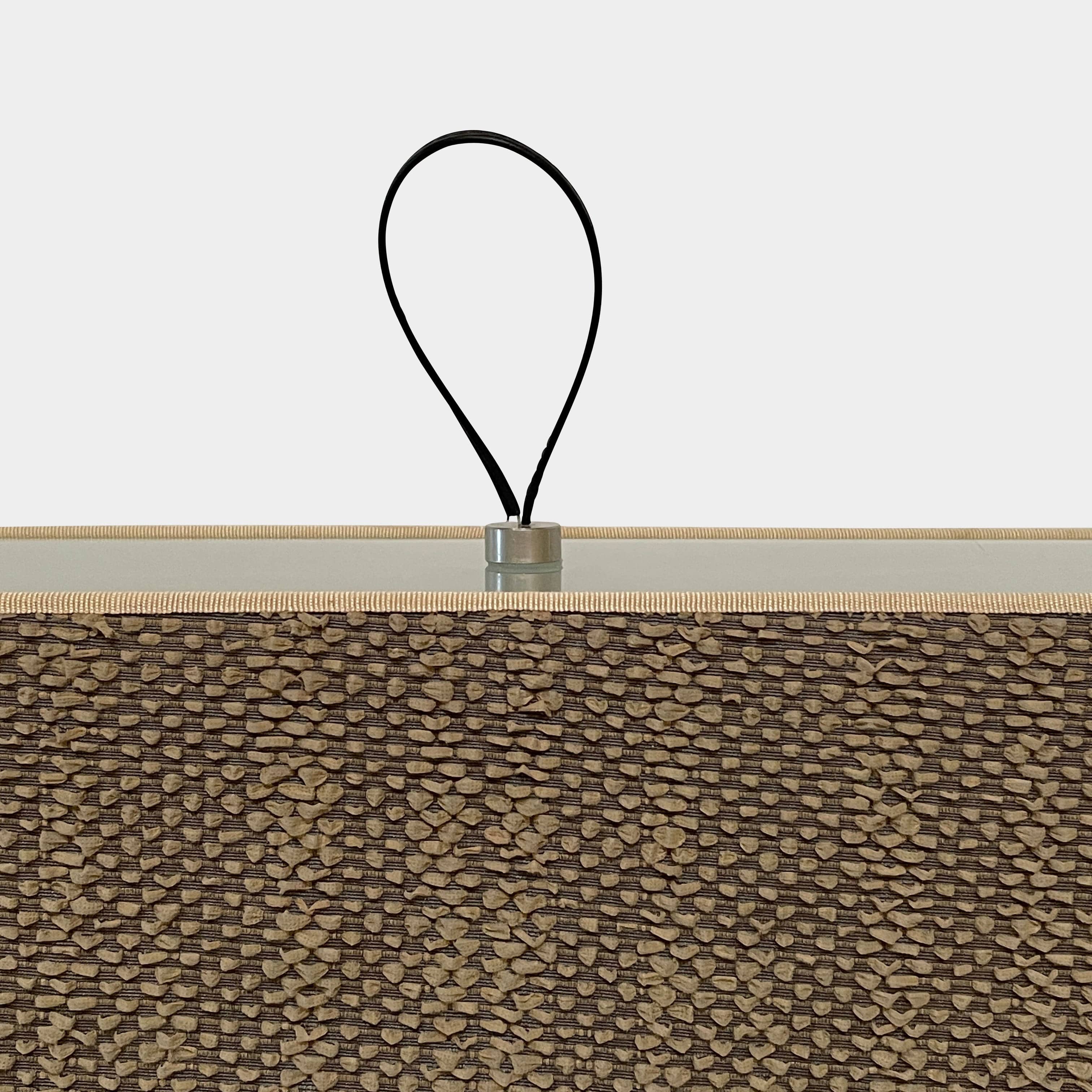 Two-tiered, textured fabric lampshade with a loop finial on a white background for the Luminara Dabliu Table Light by Luminara.