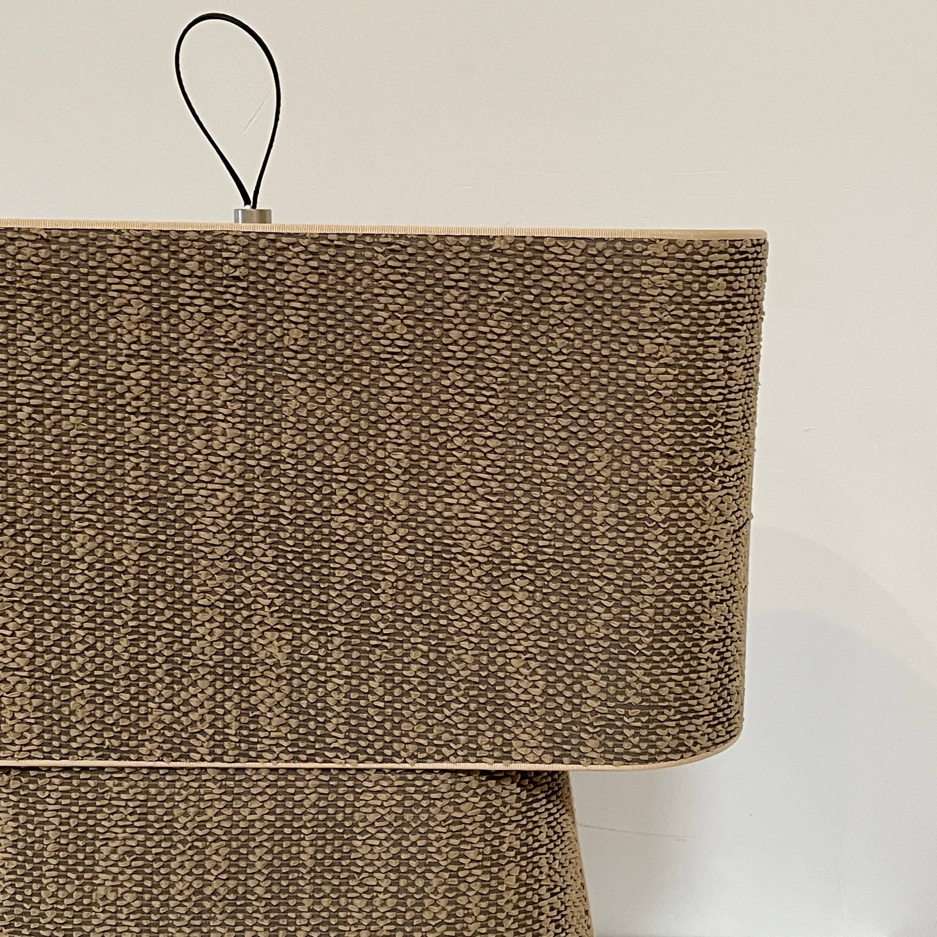 Two-tiered, textured fabric lampshade with a loop finial on a white background for the Luminara Dabliu Table Light by Luminara.