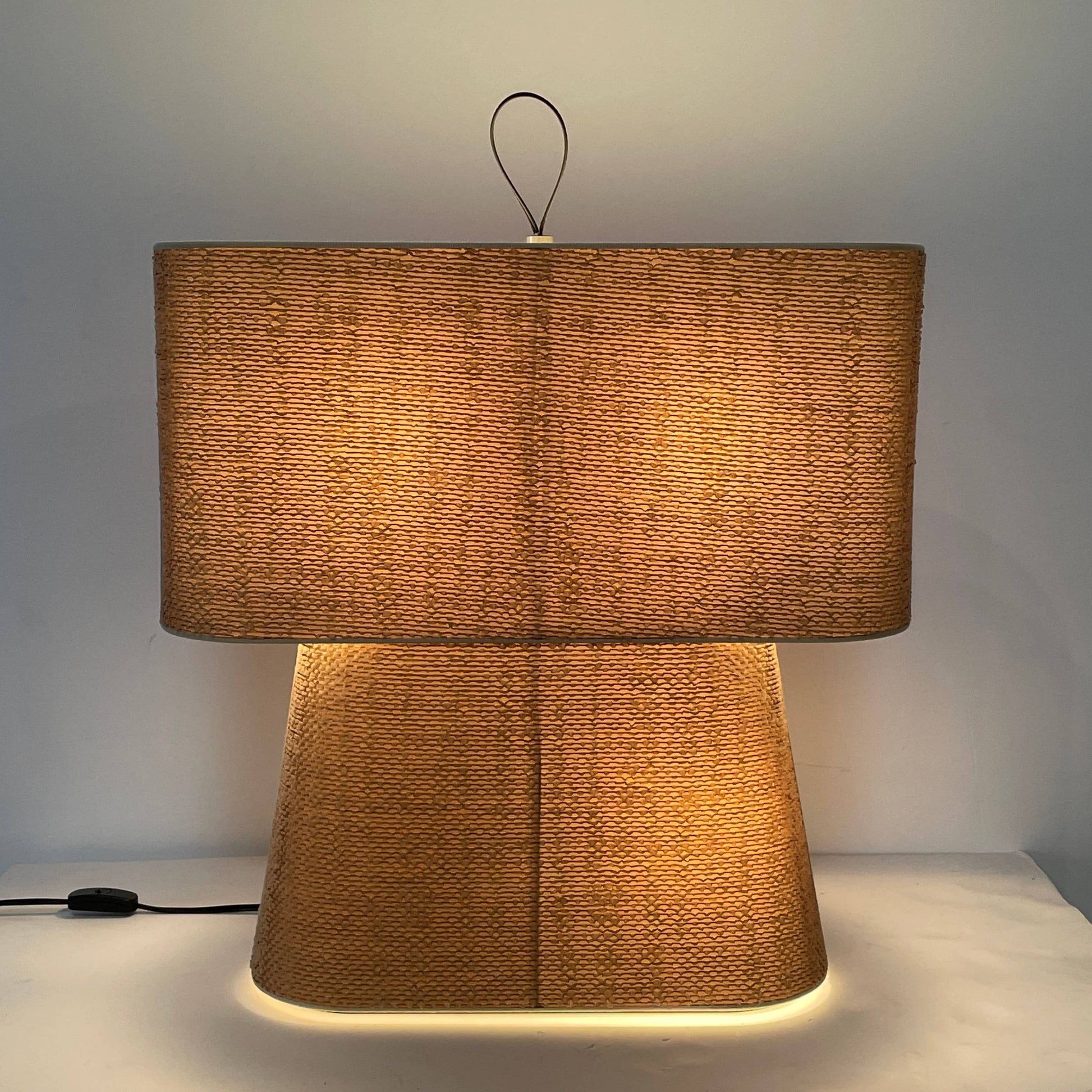 Two-tiered, textured fabric lampshade with a loop finial on a white background for the Luminara Dabliu Table Light by Luminara.