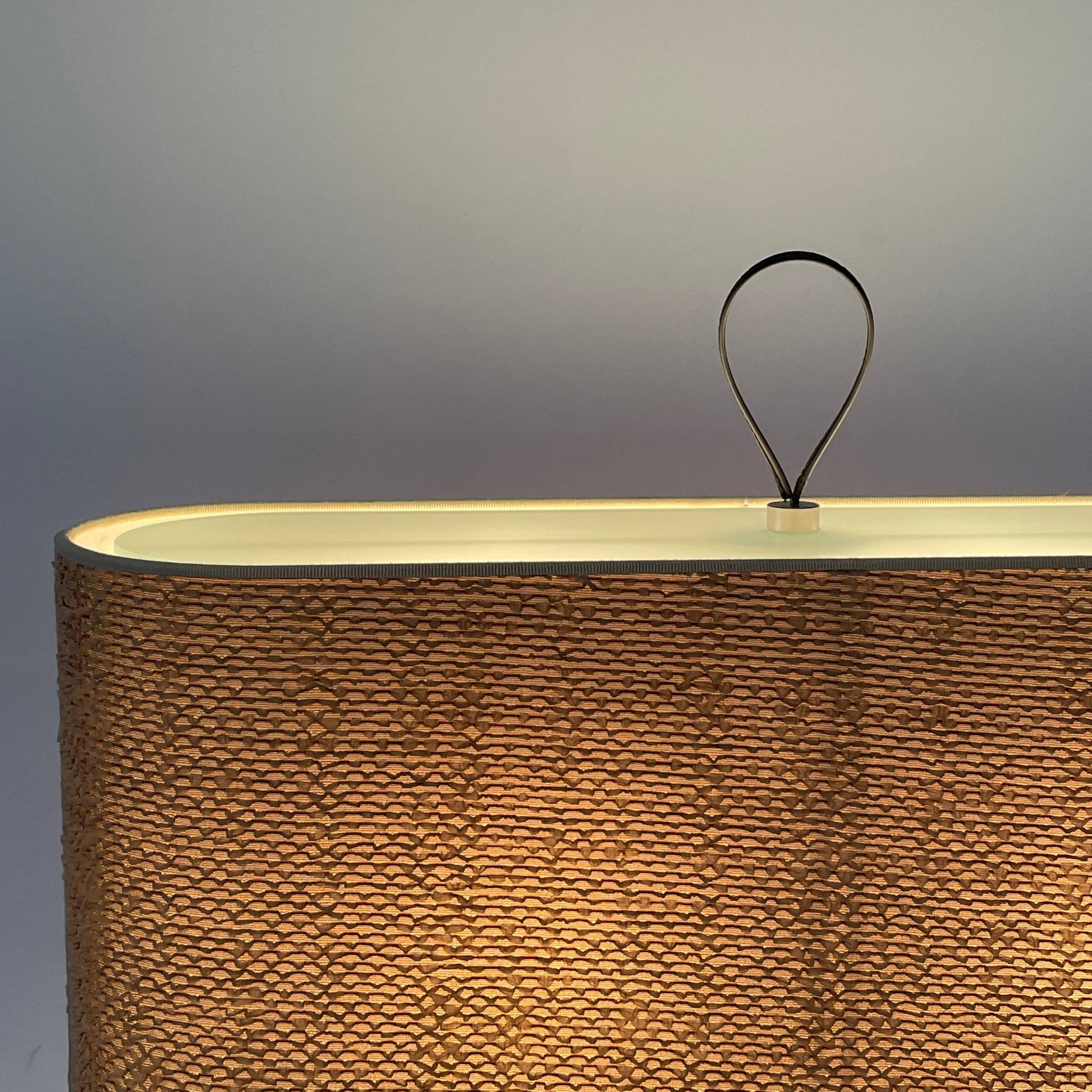 Two-tiered, textured fabric lampshade with a loop finial on a white background for the Luminara Dabliu Table Light by Luminara.