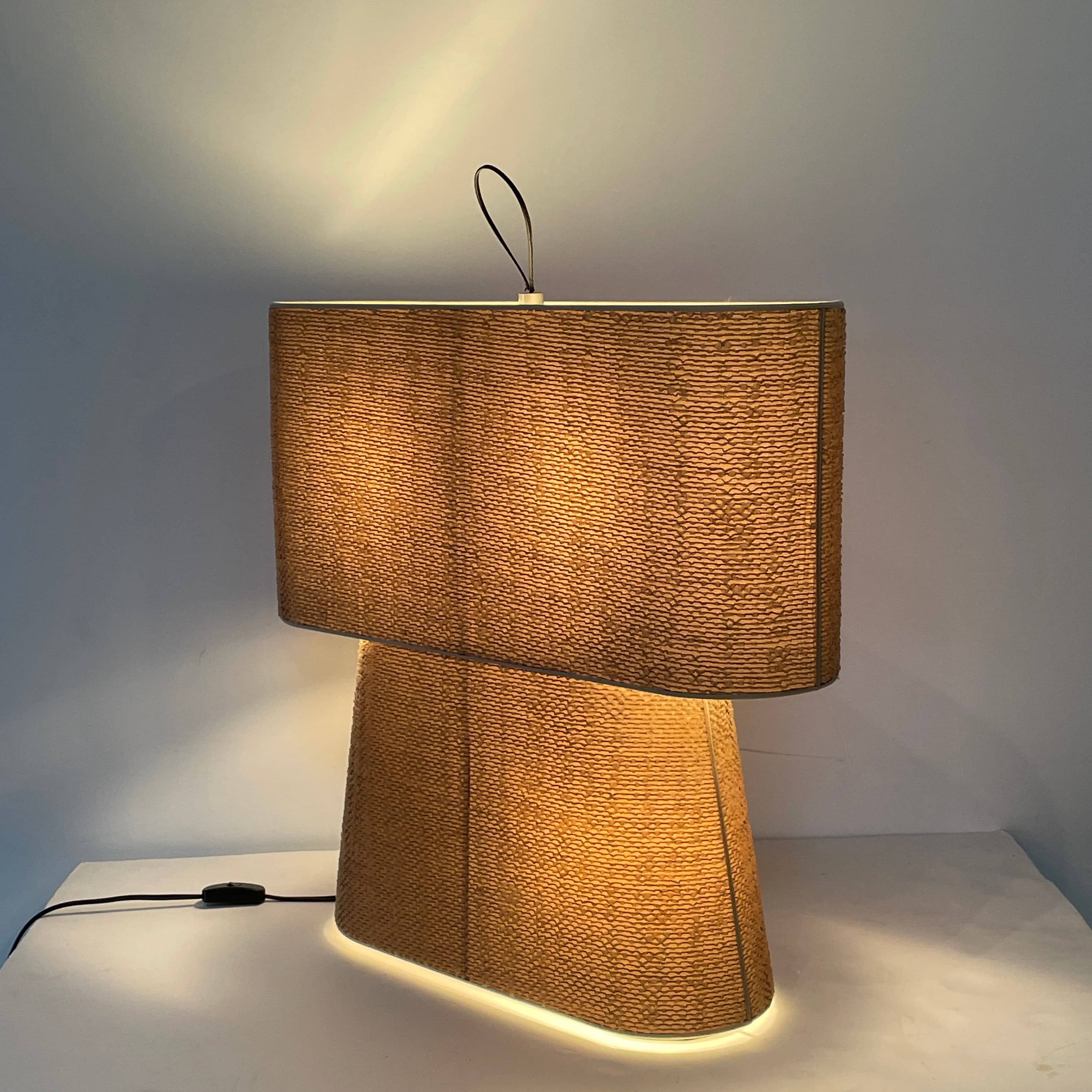 Two-tiered, textured fabric lampshade with a loop finial on a white background for the Luminara Dabliu Table Light by Luminara.