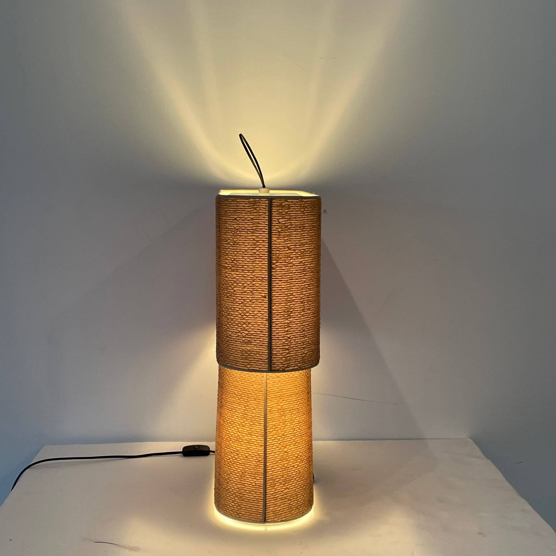 Two-tiered, textured fabric lampshade with a loop finial on a white background for the Luminara Dabliu Table Light by Luminara.