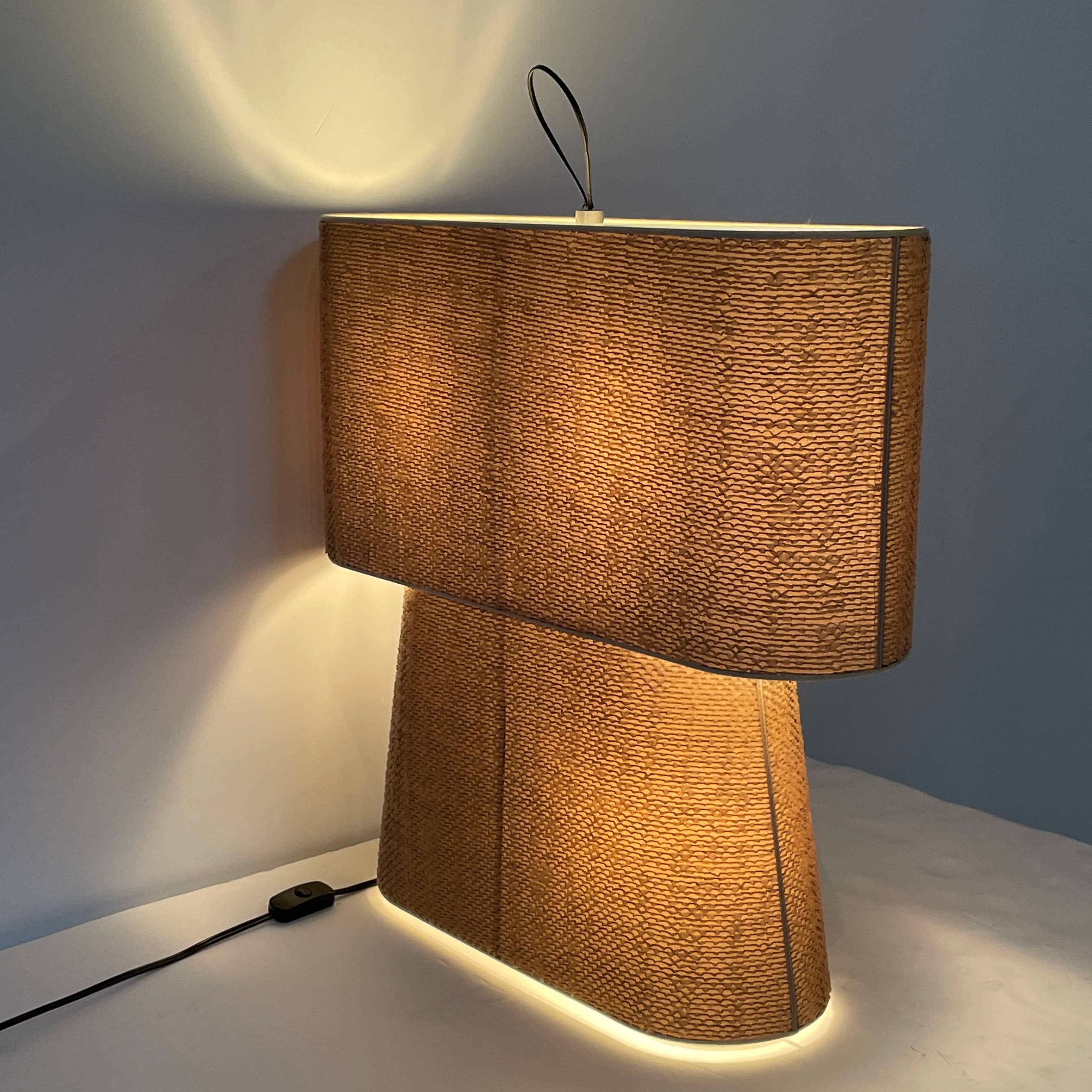 Two-tiered, textured fabric lampshade with a loop finial on a white background for the Luminara Dabliu Table Light by Luminara.