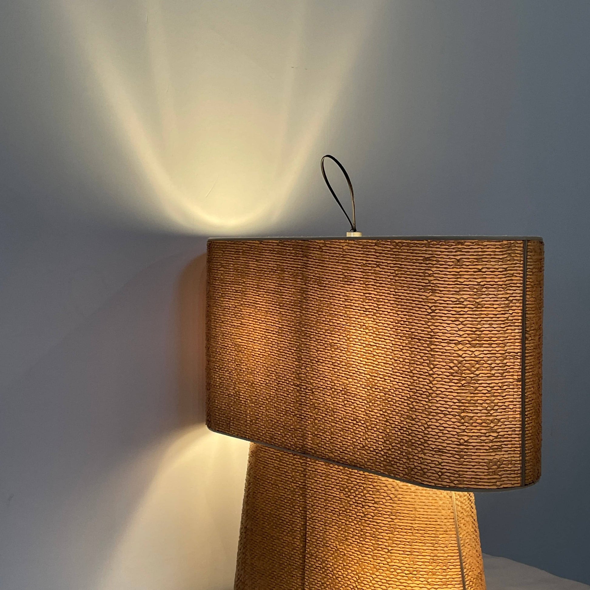 Two-tiered, textured fabric lampshade with a loop finial on a white background for the Luminara Dabliu Table Light by Luminara.