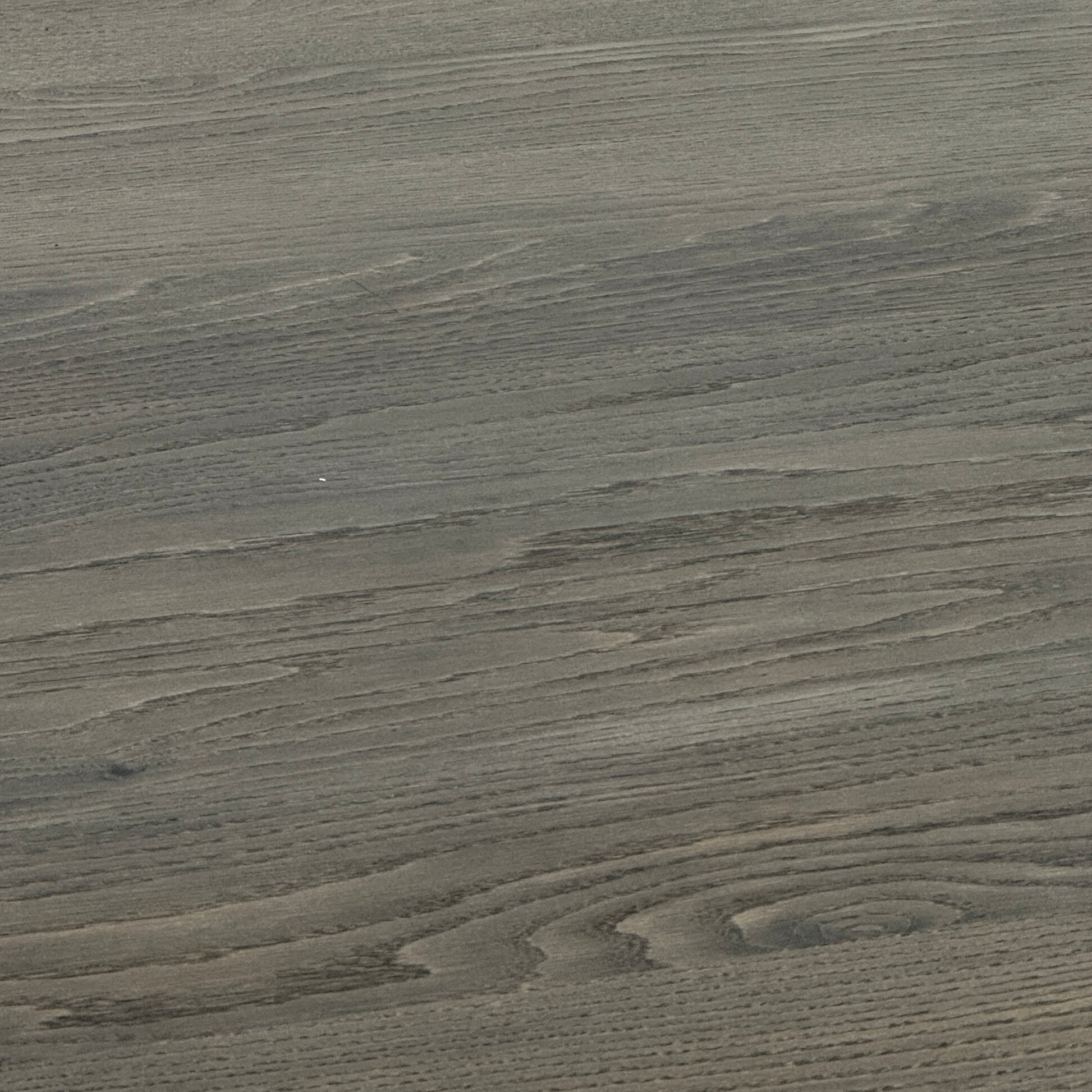 The BDDW Solid Oak dining table by BDDW features a simple, modern rectangular design and is set against a plain white wall on a polished concrete floor.